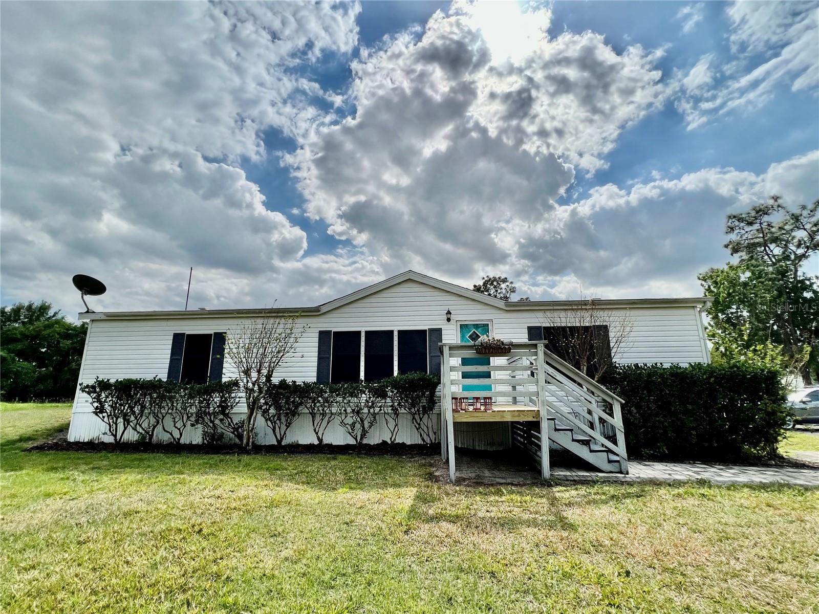 ** Price Update ** Back On Market ** Buyer Financing Fell Through **
Updated price on this beautiful piece of property at 2.10 acres coupled with a 3/2 mfg. home. Property is a corner lot and boasts a small pond, 2 livestock pens, and an outbuilding. The home features laminate floors throughout, large open living and kitchen / dining area, granite counter tops, stainless appliances, new a/c, large wooden deck and more. Schedule an appointment, come take a look and make your offer.
Note: Light Painted Shed Does NOT Convey. I’m