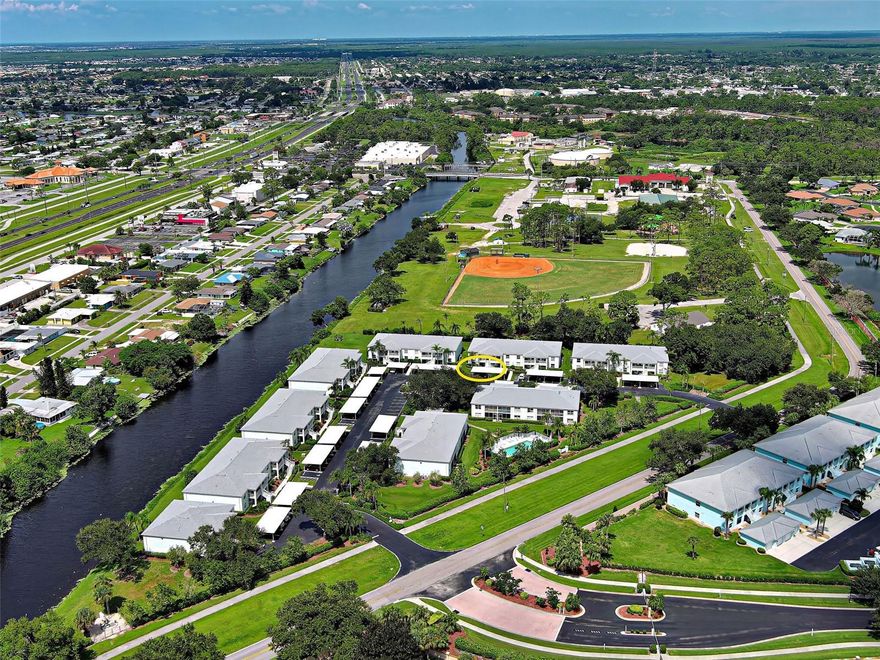 CLAIM YOUR PIECE OF PARADISE AND CELEBRATE LIVING in this perfect-in-every-way, maintenance-free 1153 SF 2-bedroom, 2-bath ground floor condo in an attractive, well-kept, friendly and caring 55+ community. The open concept floor plan provides a light, bright sundrenched home, with warmth, style and character throughout. Rear lanai, with new screens, vinyl sliders and Collaroo 50 exterior shades assures year-round comfort, and faces west to enjoy our beautiful Florida sunsets over a serene view of Dallas Park. Dallas Park provides public access to tennis and volleyball courts, picnic areas, playground and kayak/canoe launch for endless outdoor activities practically at your doorstep. The front window faces east, so you can enjoy your breakfast sunny side. Gorgeous Marazzi glazed tile throughout, with new luxury vinyl in primary bedroom (no carpet!). PGT 500 series hurricane impact windows, Bali custom double cell corded blinds and ceiling fans in living area, master suite and guest bedroom/office/den. Fabulous kitchen/breakfast nook area! Custom Quartz countertops and sink! Two (2!) large pantries/storage closets! Reverse osmosis system for drinking water! Large breakfast bar overlooks the living/dining combination providing the ideal space for entertaining guests or enjoying intimate family dinners with friends and family. The sumptuous primary suite features a sliding door that opens out to the private lanai, with a huge walk-in closet and separate linen closet as well.  The ensuite bath has an expansive countertop and large step-in shower with grab bar. The guest quarters/office/den deliver privacy when guests visit, featuring a pocket door to the private suite accommodations.  The guest bath has new Koehler hi-rise commode as well as grab bars. The laundry area is enclosed with doors and affords additional storage. Beautiful in-ground heated community pool (updated 2023) and outdoor barbecue grill, perfect for gathering with friends and neighbors. NEW ROOF AND CARPORT - 2023.  BUILDING REPAINTED - 2024.  AC has been regularly maintained, with a new dual purpose capacitor with a 5-year warranty in 2025. NO CDD.  LOW HOA FEES!  CITY WATER & SEWER (included in HOA fee, as well as maintenance of building exterior and grounds).  Pride of ownership shows ... ALL UNITS RESIDENT-OWNED - NO RENTERS!  The City of North Port offers endless opportunities for recreation and entertainment, such as world-famous Warm Mineral Springs, nearby golf courses, some of the world's most beautiful beaches, and world-class fishing and boating just a short drive away. The North Port Aquatic Park is close by. The CoCoPlum Village Shoppes provide a variety of restaurants and retails shops that are sure to meet your needs. LOVELIEST AND BEST CARED FOR CONDO AVAILABLE IN THIS PRICE RANGE.  THE PERFECT BLEND OF COMFORTABLE LIVING, CHOICE LOCATION AND AFFORDABLE PRICE!  CALL NOW; IT'S TOO NICE TO LAST!