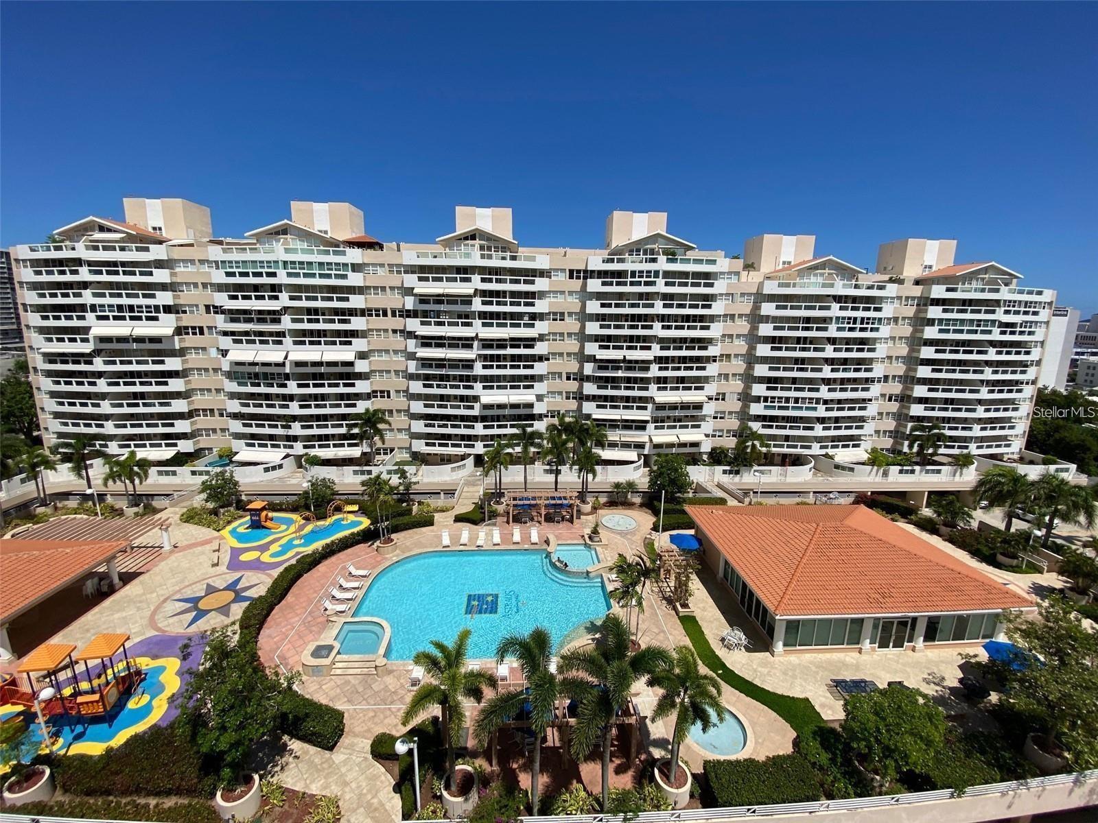 Stylishly upgraded Sub-PH apartment for sale, ideally located across from the Fairmont Hotel San Juan and just minutes from the International Airport in Isla Verde—one of the most desirable areas in Puerto Rico.
This bright and spacious unit features an open-concept layout with a generous living, dining, and family room area. The modern kitchen includes a center island, stainless steel appliances, and a laundry closet with a brand-new washer and dryer. The primary suite offers two closets and a private en-suite bathroom. A second bedroom, a full bathroom, and a convenient half-bath for guests complete the layout.
The sale includes furniture and two covered parking spaces.
Building amenities offer resort-style living: full power generator for common areas and kitchen outlets, water cistern, 24/7 security, swimming pool, jacuzzi, activity room, fitness center with sauna and steam room, playground, basketball court, and four electric car charging stations.