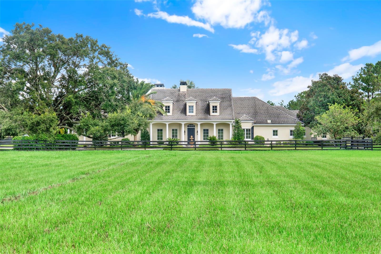 From the moment you arrive at this luxury gated custom estate on 5 luscious acres with a pool and horse barn you will be in heaven!
Enter though the private gate and you will find a circular brick paver driveway with a centerpiece fountain and mature landscaping.
Step through the door into a foyer and be impressed by the spacious living room and centerpiece gas fireplace. Two set of French doors create lots of natural light and overlook the stunning tropical pool and spa.
A custom craftsman kitchen boasts a large island, top of the range appliances and is open to a spacious dining area.
The appliances include a Viking electric stove, Miele gas grill top, Subzero cooling drawers, a Bosch convection double oven, Subzero oversized fridge/freezer and a wine fridge. There is also a large walk-in pantry.
Off the kitchen is an office overlooking the front yard, a half bath, the laundry room and a spacious 3 car garage, also the entrance to the 32 x 16ft 5TH BEDROOM/Bonus room upstairs with its own full bathroom.
On the other side of this stunning home you will find a family room with another fireplace and a door leading out to the pool area, a library area , another half bath, then three spacious bedrooms with their own bathrooms and a storage/safe room. The private primary spacious primary suite has a door leading to a small patio outside, a luxurious bathroom and huge walk-in closet.
The outdoor backyard oasis will thoroughly relax you - enjoy the large covered back porch with built in gas grill overlooking the designer style pool and spa and tropical landscaping. a full bathroom is accessible from the pool area for your convenience.
A Tesla solar system to help reduce your electricity bills and a whole house generator add to the list of attractions of this stunning home!
For your horses you can enjoy 4 fully fenced grass pastures, a well built 2-stall concrete barn and tack room. There is also a 2 stall shed row barn in one of the pastures allowing up to 4 horses comfortably.
A separate 12 x 30 storage shed is great for storing hay and feed and equipment.