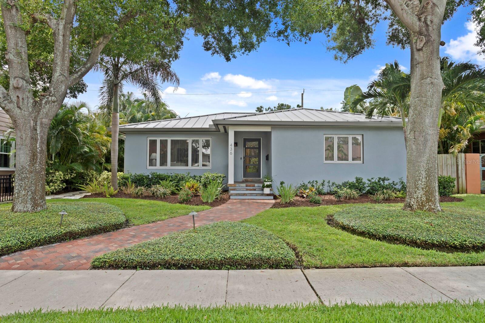 Charming Old Northeast home, priced below appraised value, offers the perfect blend of historic character, modern comfort, and energy-efficient living. This beautifully maintained 2-bedroom, 2-bath block construction home features over 1,800 sq ft of light-filled living space and is truly move-in ready. A standout feature is the 345 sq ft screened Florida Room with vaulted cypress ceilings and a gas grill hookup—perfect for year-round entertaining or relaxing in comfort. The designer kitchen (2022) showcases quartz countertops, a full-height quartz backsplash, custom cabinetry, and premium stainless-steel appliances—offering both beauty and functionality. Original oak hardwood floors, arched doorways, and cove ceilings preserve the home’s timeless appeal, while modern upgrades enhance everyday living. The spacious primary suite includes a custom California Closets walk-in closet, and the cedar-lined hallway closet provides natural storage protection. This home is built for efficiency and peace of mind with fully paid-off solar panels with battery backup, a 24-gauge standing-seam metal roof, double-pane Pella windows, and 1.5” Isobar insulation. The private, fenced backyard features professionally installed turf for low-maintenance outdoor living and deep well irrigation for lush landscaping with minimal cost. A rare attached 2-car garage (570 sq ft) offers generous storage and daily convenience. Importantly, the home has never experienced water intrusion, and the current flood insurance policy is transferable at approximately $1,001/year. Ideally situated in the heart of St. Petersburg’s Historic Old Northeast, this home offers exceptional walkability to waterfront parks, local cafes, restaurants, museums, and boutique shopping. It’s the perfect blend of an active, walkable lifestyle with the tranquility and charm of a classic neighborhood.