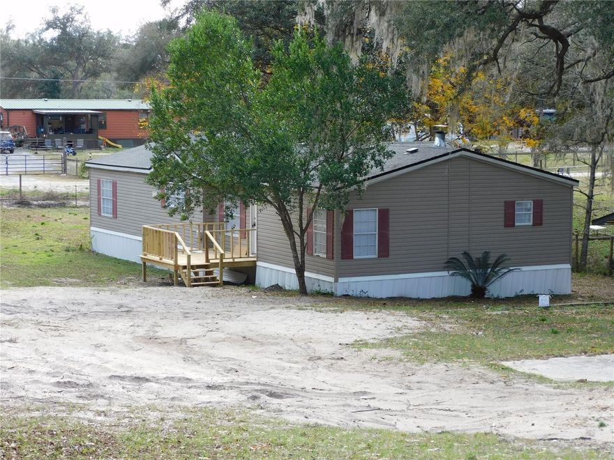 1999 manufactured home on owned land with adjacent vacant lot — .82-acre total across two parcels; no lot rent. Recent updates including a new roof, new HVAC, and new flooring mean the big-ticket items are already done. Move in and enjoy the space without the projects. The property includes a small shed, a large workshop shed, and a gazebo-style outdoor dining pavilion perfect for family gatherings. Located just minutes from Ocala National Forest, the setting appeals to buyers who enjoy fishing, zip lines, horseback riding, and many other outdoor pursuits. Inside, an open floor plan connects the living areas to a kitchen outfitted with all-new stainless-steel appliances — refrigerator, electric range, microwave, and dishwasher — plus a center island and breakfast bar. A working fireplace anchors the living space. Three large bedrooms, plus two bathrooms: one with a single-vanity tub/shower combo, the other with dual vanities and a walk-in shower. Privacy, space, and nature access — without the lot rent. Schedule a showing now.