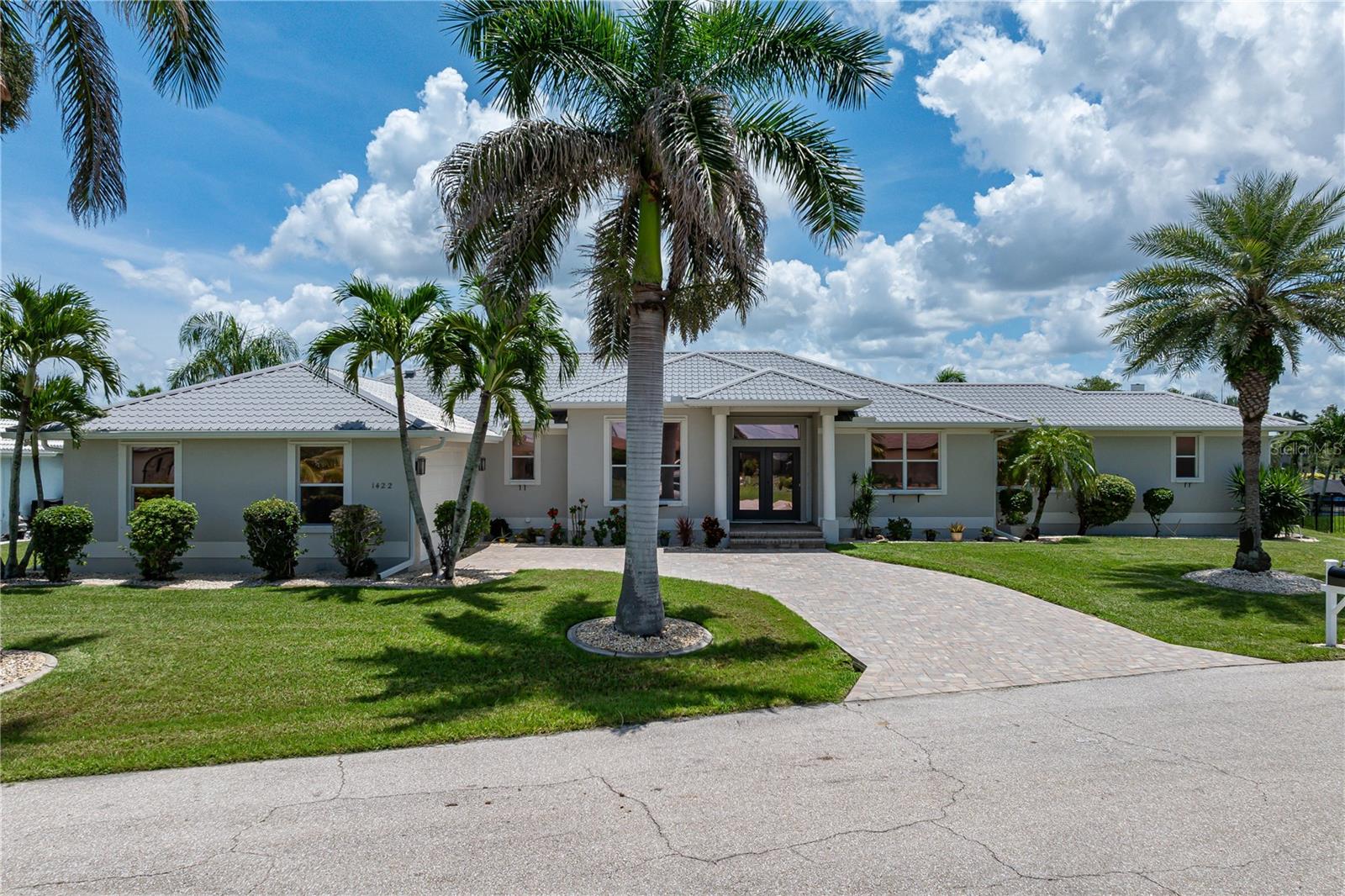 UPDATED WATERFRONT GEM IN PGI W/**NEW METAL ROOF**, 132 FT OF SEAWALL, VIEW OF INTERSECTING CANALS & QUICK BOATING ACCESS - Located on a quiet cul-de-sac in Punta Gorda Isles, this beautifully updated 3 bed/2.5 bath waterfront home delivers a spacious, open floor plan filled w/coastal elegance & thoughtful upgrades. Boating enthusiasts will appreciate the 132 ft of seawall, 30ft concrete dock & quick boating access to Charlotte Harbor. The over 2,300 sq ft of living space showcases a modern coastal aesthetic w/a mix of tile & wood flooring throughout the main living areas. Architectural details include a welcoming foyer w/columns that opens directly to the lanai extending the living space outside, soaring cathedral ceilings in the kitchen & master bedroom, tray ceiling in the formal living room, crown molding in the den/office area as well as an abundance of natural light through large windows & sliding glass doors. The chef-inspired kitchen features granite counters, a striking mosaic backsplash, blonde cabinetry, stainless appliances, and an abundance of counter & cabinet space that includes an angled breakfast bar w/seating. The kitchen opens to both a formal dining room & breakfast nook - both that offer pool & canal views. The breakfast area even features a mitered window for an unobstructed water view. The private master suite has walk-out access to the lanai, two walk-in closets & a spa-like master bath w/dual sinks, a textured mosaic accent wall w/floating over sink mirrors, a corner shower w/frameless glass enclosure & two shower heads. Two additional guest bedrooms share an updated full bath and there’s also a pool/half bath on the lanai. Step onto the extended screened lanai w/picture frame pool cage where multiple seating areas surround the in-ground, heated pool and a retractable awnings offer a perfect blend of sun and shade. Lush, tropical landscaping surrounds the home. Palm trees & blooming plants line the pathway leading to your private dock in the backyard. Avocado & Meyer lemon tree can be found on the property as well. The extended concrete dock features a 10,000 lb boat lift w/two new motors plus water & electric hook-ups. Reach open water in about 10 minutes from your backyard. Recent upgrades include a new metal tile roof & gutters (2023), new pool heater (2023), new paver driveway (2024), kitchen remodel (2019), hot water heater (2022), and new wood floor in the dining room (2024). Other amenities are modern light fixtures, whole-house hurricane protections, & an oversized, two-car garage w/ample space and a built-in workshop. Some furniture is negotiable. Make an appointment today & discover your place in paradise!