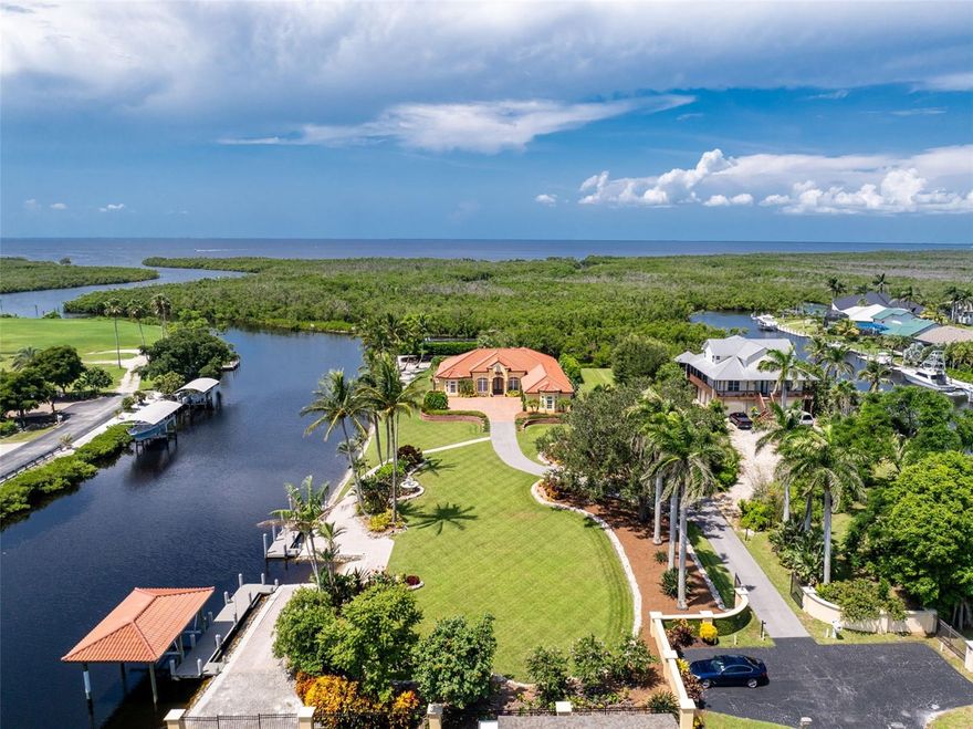 Experience an unparalleled waterfront lifestyle with this extraordinary Punta Gorda compound—an estate unmatched in privacy, land, and luxury throughout the surrounding area. Set on just under 2 acres with no deed restrictions, this private gated property offers resort-style living, exceptional boating amenities, and expansive grounds rarely found in Southwest Florida. Located on a quiet dead-end canal with minimal boat traffic and an easy idle-out to Charlotte Harbor, the setting is peaceful, private, and ideal for boating enthusiasts, and the home itself has never flooded. Built by Arthur Rutenberg and pristinely maintained by its original owner, the residence spans 3,279 sq ft with an open layout designed for elevated entertaining. The updated kitchen features Bosch black stainless appliances and generous workspace, while the living room showcases a Lake Como–inspired mural that enhances the Mediterranean feel of the home. The primary suite offers a spa-inspired bath featuring a stunning rain shower, an electric bidet, separate vanities, and a beautiful stone soaking tub framed by elegant rain glass, all positioned to capture serene morning sunrise views to begin your day. The kitchen, family room, and primary suite were all refreshed in 2022. The one-of-a-kind den is custom-built with five different woods, creating a warm, rich, and distinctive statement space ideal for an executive office or optional additional bedroom. Outdoor living defines this compound, featuring an open-air heated saltwater pool and spa, a private shell beach and firepit, and luxurious landscaping that adds a park-like setting, along with multiple seating areas both under-truss and within a charming gazebo off the guest room surrounded by a garden—perfect for enjoying expansive sunset views and watching boaters move through Buckley’s Pass. For boaters, the property offers two 40-foot docks, a boathouse over the boat lift with power and water, and a private boat launch—an exceedingly rare amenity in the area—along with smooth idle-speed access to Charlotte Harbor. Additional features include a 3-car epoxy-floor garage, impact windows and doors, a clay roof, an updated water heater and pool pump, and low Charlotte County taxes. With nearly 2 acres of usable land, the estate also provides ample space to add a pickleball court, tennis court, basketball court, or a full guest house for enhanced future value. This remarkable offering is more than a home—it's a private coastal compound delivering unmatched land, luxury, privacy, and boating amenities, standing alone as one of the most distinctive properties in all of Southwest Florida.