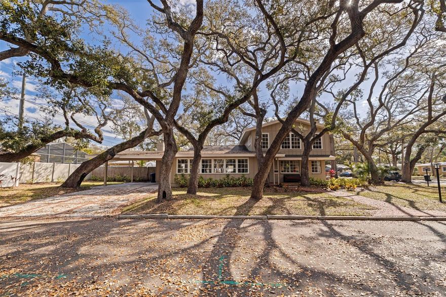 This masterful art piece of St Pete history includes deeded water access to the Boca Ciega Bay and is located on a private, dead-end street! The home co-owns water access directly across the street, where neighbors gather and launch kayaks off the private beach. This one-of-one a kind home features brick floors/fireplaces, custom wood carpentry, vaulted ceilings that fill the home with natural light, and ceiling fans in every room. The open floor plan seamlessly connects the main living room to the updated kitchen, sunroom, and den/cafe. A custom quartz kitchen island is the centerpiece, with cabinets and soft-close drawers on both sides as well as built-in phone charger outlet pop-ups. The primary suite is on the first level in addition to 1.5 bathrooms and a large flex room that could be a bedroom or a family room. The hot water heater, stove, microwave, and dishwasher were replaced in 2025, and the refrigerator and ductless A/C unit were new in 2024. Ancient, storm-tested oak trees shade the home, and the fenced-in backyard of healthy grass includes a beautiful gazebo. Between the 2-car covered carport, long driveway, and corner lot of street parking, this home is perfect for entertaining. This unique work of art is the crown jewel of Jungle Terrace.