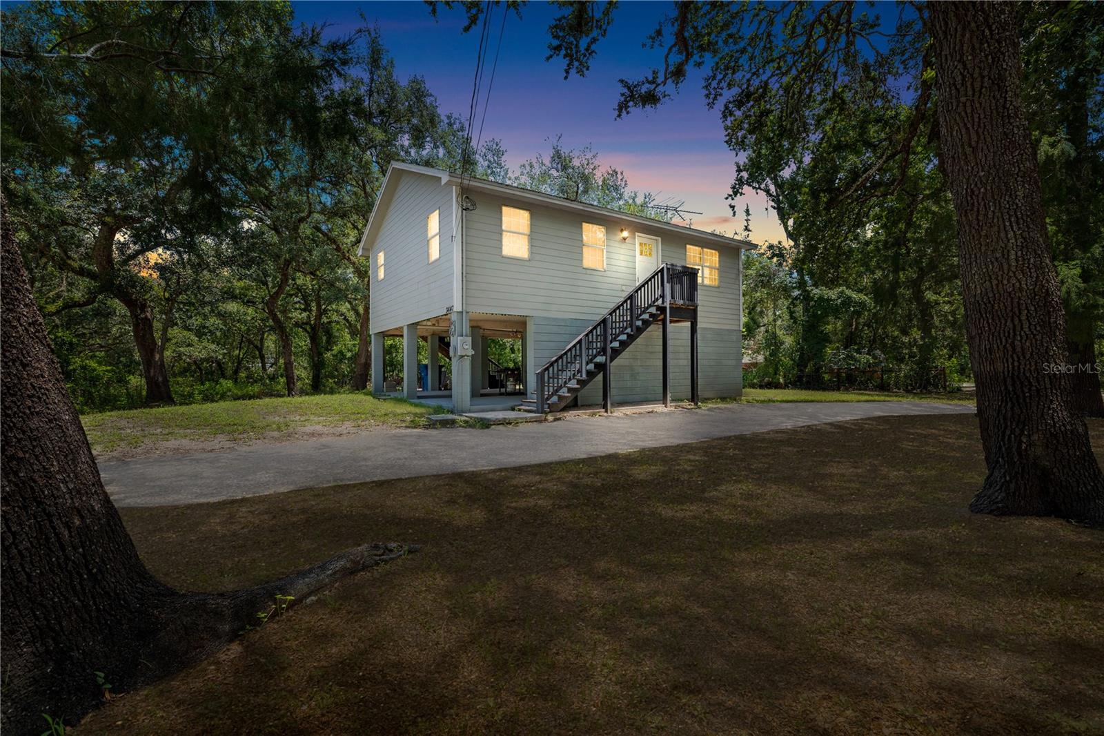 One or more photo(s) has been virtually staged. Set beneath a canopy of oak trees just outside of Dade City, this fully furnished 3 bedroom, 1
bathroom stilt home offers the perfect mix of rustic charm, modern upgrades, and peaceful
surroundings. Whether you are searching for a weekend getaway, full-time home, or Airbnb-
ready investment, this 2023 renovated retreat is the one you have been waiting for! Stroll up the
staircase to an open-concept living and dining area featuring calming modern paint colors, a
ceiling fan, updated light fixtures, and wood-look tile flooring that runs throughout the entire
home. The kitchen brings a warm modern farmhouse vibe with custom shaker cabinetry,
butcher block countertops, a herringbone backsplash, a 4-piece stainless steel appliance
package, and a convenient stackable washer and dryer. All 3 bedrooms are set near the
beautifully updated full bathroom, featuring a new tub/shower combination, updated lighting
and fixtures, and a stylish new vanity. On the ground level, enjoy an inviting open patio with a
fire pit, a utility/storage room, and a spacious 3-car carport, currently used as an open-air
covered lounge - ideal for relaxing and entertaining! Situated in a peaceful rural setting and an
unbeatable location, only minutes from the Withlacoochee State Trail, the Withlacoochee River,
and I-75, this home offers the tranquility, updates, and convenience you have been waiting for!
Don't miss the opportunity to own your piece of Florida country paradise!