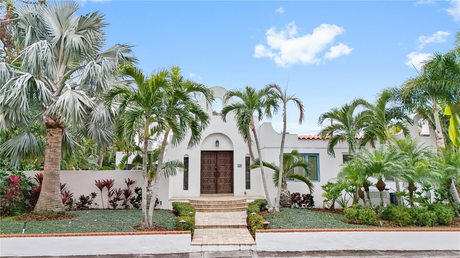 Mediterranean compound estate double lot in historic Old Northeast! On a commanding corner lot in St. Petersburg’s desired historic Old Northeast, this Mediterranean-inspired compound estate offers a rare blend of architectural distinction, sustainable systems and multi-residence flexibility. Renovated by award-winning Strobel Design Build, the three-bedroom, two-bath primary residence showcases custom design features including bespoke metal arched double-opening doors and handcrafted windows that frame the estate’s lushly landscaped grounds. All on .28 acres, 93x131. Solar panels—owned outright—support energy efficiency, while natural gas services the gourmet kitchen and Aqua Lounge fireplace. A seamless indoor-outdoor connection flows from the open-concept interiors to a screened lounge, where gas fire and ceiling fans enable all-season entertaining. Beyond lies a travertine pool deck and a saltwater pool with integrated Fastlane Pro system for lap training or leisure. Designed for privacy and versatility, this gated compound is further enhanced by The Annex, a two-bedroom, one-bath guesthouse—ideal for guests, extended family or income generation, The Nest, a detached one-bedroom, one-bath garage apartment with private entry. Four power meters, offering zoning flexibility for future development or estate planning. A caged shed for the ideal vegetable garden or orchids. Concealed behind layered landscaping and architectural hardscapes, the property provides a resort-style experience in a private estate setting—in this desired neighborhood, all just moments from waterfront parks, fine dining and St. Petersburg’s Beach Drive district.