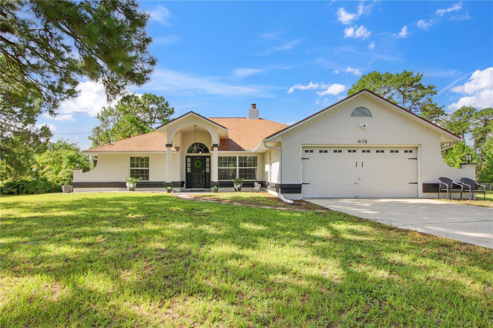 Beautiful custom built 3 bed 2 bath concrete block home on two well-maintained acres with attached 2 car garage and an additional 1200 sq ft detached garage located on a quiet peaceful private drive conveniently located 20 minutes from the New Smyrna beaches but still close to Orlando and Sanford airports.
Remodeled in 2021 with LVP flooring throughout the entire home, magnificent quartz countertops in the kitchen including smart appliances and a fireplace that will wow anyone who walks through the front door. Vaulted ceilings throughout the home enhance the beauty of the custom construction. The main garage has a dedicated 30 AMP EV charging outlet. New 3 ½ ton AC unit and 40 gallon smart hot water heater installed in 2024.
Your detached 30 X 40 garage features LED lighting throughout, a water filtration system installed inside and a large RV pad with power hookup and separate septic. Bring your boats and other toys as this garage can hold it all.
Your 3 horse pole barn has power and water with 2 separate fenced pastures for grazing allowing for multiple horses if desired. You can see the beauty of all this land from your large screened porch off the back of the house.
Furniture, mowers and other toys negotiable. TV’s mounted to the walls convey. Come see how close you are to everything while still feeling a world away. Owners are the current residents and the listing agents .