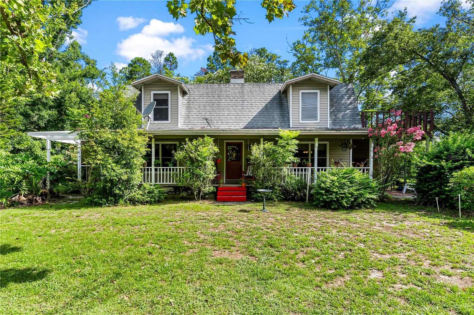 Welcome to your dream countryside escape! Nestled on 7 pristine acres, this gated picturesque farm-style cottage offers the perfect blend of rustic charm and peaceful living. Tucked among lush, mature trees and surrounded by rolling green pastures, this charming 3-bedroom, 2.5-bath home offers the perfect balance of country living with cozy aesthetics. Nestled on peaceful acreage, this home features classic wraparound porches that invite you to slow down and savor the simple pleasures of life. Imagine starting your morning with a cup of coffee on the porch swing, or evening lemonade while enjoying the sights and sounds of birds and grazing animals in the open fields, every corner of this land tells a story of natural beauty and rural tranquility, like right out of a storybook. This property includes a detached two-car garage for secure parking and storage, plus a separate workshop ideal for hobbies, projects or unwinding in your own space. What makes it even more special? A full unfinished basement-a rare and valuable feature in Florida real estate, perfect for creating a custom bonus living space! Whether you envision a hobby haven, guest suite or media room, this hidden gem offers room to grow. When you step inside, you'll find a warm, inviting interior with spacious living areas, stunning stone wood-burning fireplace that serves as a striking centerpiece, seamlessly connecting the living room and kitchen, bringing warmth, to the heart of the home. This open concept cottage, has a well-appointed kitchen, and cozy warm bedrooms filled with natural light and lots of closet space. Wake up to the tranquility in your primary suite, which opens onto a spacious private balcony, offering that indoor-outdoor connection in total privacy that allows you to enjoy your own beautiful property from the top! Schedule a tour today!