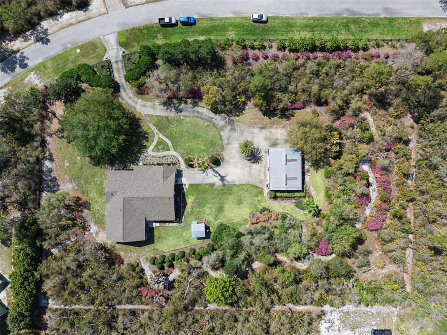 Welcome to this truly exceptional estate where thoughtful design, modern updates, and peaceful outdoor spaces come together perfectly. Tucked away on 2.24 beautifully landscaped, park-like acres in Eustis, this nearly 3,600-square-foot residence offers a rare mix of space, privacy, and quality renovations—all with a subtle country feel to welcome you home. 
Fully transformed in 2023, this home was redesigned and expanded, for both style and functionality. Inside, you’ll find an expansive-open concept layout highlighted by a stunning 900-square-foot great room that seamlessly combines the kitchen and living space—perfect for hosting friends and everyday living. Durable, wood-look tile runs throughout the entire home for a clean, cohesive foundation.
The brand-new kitchen is the heart of the home, featuring striking brick walls that add texture and charm. With updated 2023 appliances, a large prep island, and a walk-in pantry, it’s built for real life. Quartzite countertops offer a high-end finish that’s also durable and low-maintenance. The same quartzite surfaces flow from the kitchen into the fully renovated bathrooms, tying the design together seamlessly. You’ll also notice plenty of smart storage tucked away throughout the house to keep things organized.
A split floor plan ensures privacy, with three large bedrooms and three and a half bathrooms, all redone with beautiful materials and quality craftsmanship.  Additional living spaces include a dedicated office, dedicated dining area, and an inviting living room—offering flexibility for any lifestyle.
Step outside and experience your own private retreat. The grounds are meticulously maintained with lush landscaping, shaded walking paths and a peaceful, park-like setting that enhances the home’s quiet, country-inspired ambiance. A circular driveway provides ample parking and a great first impression.
Car enthusiasts, hobbyists, or business owners will appreciate the impressive 30x40 outbuilding, complete with electricity and space to accommodate up to eight vehicles—perfect for a workshop, storage, or garage use.
This home is as practical as it is beautiful, featuring major system upgrades including a 2021 roof, 2022 AC, two tankless water heaters, all-new PVC plumbing, and fresh interior and exterior paint completed in 2023. Every inch reflects pride of ownership and meticulous care.
A rare opportunity to own a fully renovated, move-in-ready estate with acreage, modern amenities, and timeless appeal—this property truly stands apart.