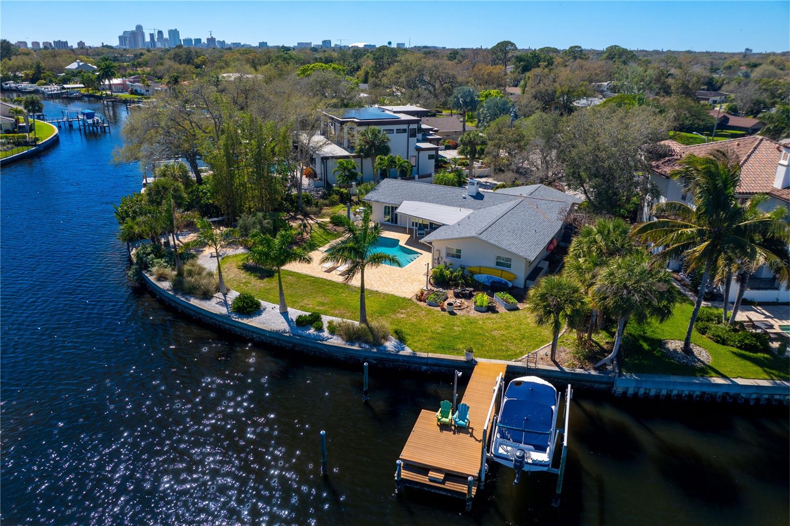 Under contract-accepting backup offers. This exceptional waterfront property, in the prestigious Snell Isle Estates, offers a rare opportunity with an expansive 164 feet of water frontage on an oversized 18,099-square-foot lot. While the home sustained flood damage during Hurricane Helene, was remediated by the seller and could be renovated, the potential for creating a remarkable waterfront residence is limitless. Envision a custom-built luxury home designed to maximize breathtaking water views while providing an unparalleled living experience. Embrace waterfront living, where you can indulge in activities such as boating, kayaking or paddle boarding. The property features a thoughtfully designed composite wood dock equipped with electric and water service, as well as a 10,000-pound boat lift. Strategically positioned on far north side of the lot, the dock ensures unobstructed panoramic vistas. If the choice is to renovate, recent 2023 updates include a new shingle roof installed in 2023, plus a resurfaced and retiled pool converted to a salt system in addition to hurricane-impact windows and doors installed in 2012. On a quiet street, this prime location is just minutes from the Vinoy Clubhouse and Golf Course, as well as the vibrant downtown St. Petersburg scene, offering world-class dining, art galleries and museums. Additionally, Tampa International Airport is conveniently just 30 minutes away. For those seeking to build their dream home in one of the most desirable waterfront settings, this property presents an extraordinary opportunity. Don't miss the chance to create your slice of paradise in this distinguished community.