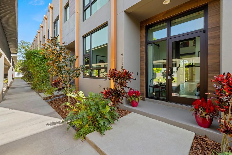 LAST CHANCE BEFORE IT"S TAKEN OFF THE MARKET FOR THE HOLIDAYS!! **Up to $5,000 towards closing costs with seller's preferred lender! ** INVESTORS - Previous units rented for ~$4,000/mo and it can be sold  furnished & decorated! Welcome to this striking 3-bedroom, 3-bathroom ultra-modern loft nestled in a secure gated community, where architectural design meets effortless luxury. From the moment you step into this end-unit townhome, you're greeted by dramatic exposed steel beams, sleek tile flooring, and a statement chandelier that sets the tone for this one-of-a-kind space.The expansive floor-to-ceiling window in the living room floods the home with natural light, complemented by a skylight that brings the outdoors in. Each generously sized bedroom features its own en-suite bathroom for maximum comfort and privacy. Thanks to the 24-foot ceilings, on the second floor loft you will have open air views of the downstairs. Take the stunning spiral staircase to the third floor private rooftop terrace, perfect for entertaining or relaxing under the stars. One bedroom offers peaceful pond views, and with no backyard neighbors, you’ll appreciate the added tranquility. A brand new roof adds peace of mind, while the 1-car garage and additional carport space provide ample parking. With clean modern lines, industrial accents, and thoughtful design throughout, this loft is more than a home—it’s a lifestyle. Just 20 minutes to downtown Tampa, you’ll enjoy quick access to the city while retreating to your private modern sanctuary. Don’t miss this rare opportunity—schedule your private showing today! Seller is offering the option to purchase the majority of the furniture and artwork!