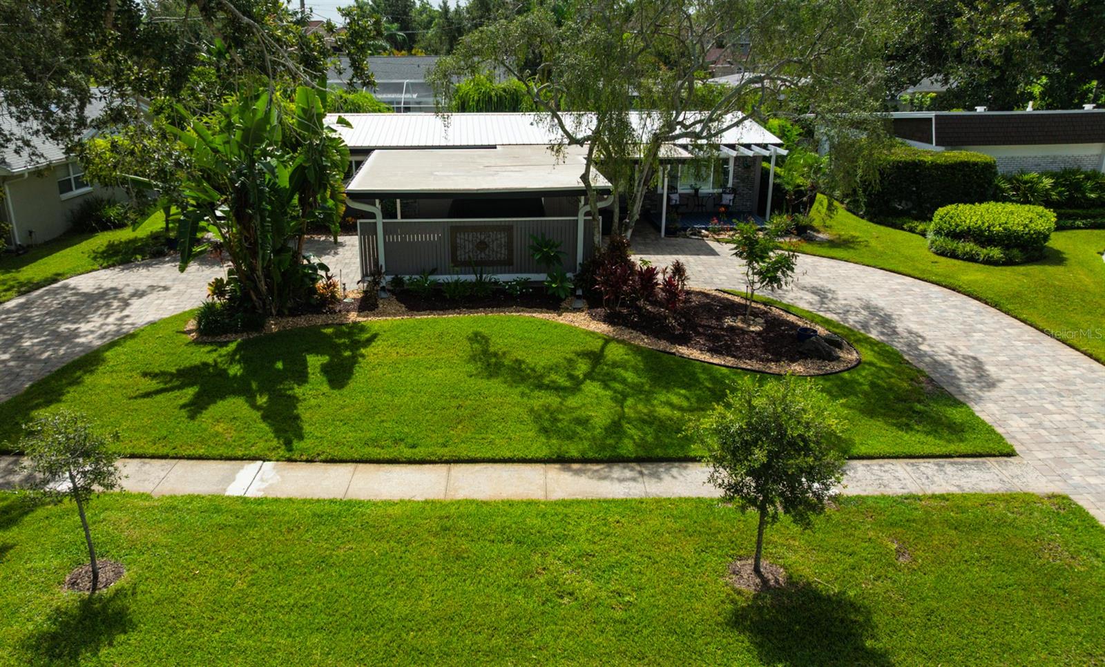 Welcome to this beautifully maintained Mid-century modern home located in the highly sought-after community of Original Carrollwood. This 3-bedroom, 2-bathroom home offers approximately 1,400 square feet of well-designed living space with a vaulted ceiling in the living and dining rooms, crown molding, 5 ½ inch baseboards, and custom tile and brick accent walls throughout.
Exterior & Curb Appeal
Beautifully landscaped front yard with Mega Olde Town Sierra pavers (installed 2016)
Large circular driveway for easy access plus carport for two vehicles
Driveway can easily accommodate up to four cars
Hurricane impact windows (installed 1/3/2022)
Metal roof (installed 6/8/2020)
NEW Rainbird irrigation system (front yard, installed 3/7/2025)
Interior Features
Vaulted ceilings in main living and dining areas create an open, airy flow
Kitchen with solid wood cabinetry, 42" uppers, granite countertops & backsplash
Dual pantries with excellent storage
French doors lead to a screened porch and a cozy pergola in the private backyard
Plantation shutters throughout (except kitchen window and French doors)
Bedrooms & Bathrooms
Private hallway leads to all bedrooms and updated bathrooms with tile surfaces and quartz countertops
One bedroom currently used as an office includes a fire-resistant safe
GE Washer (2020) and Dryer (2022) included
Recent Upgrades & Appliances
HVAC system: 2.5 ton, 14 SEER (installed 8/13/2019; serviced 4/28/2025)
Water heater (2016)
Frigidaire Professional refrigerator and dishwasher (8/2015)
GE Café range and microwave (8/8/2022)
Garbage disposal (replaced 7/1/2024)
Community Amenities
Residents of Original Carrollwood enjoy exclusive access to sandy beach on 210-acre Lake Carroll (ski-sized), including:
Private boat ramp, fishing pier, and picnic area
Community events like Christmas Eve luminaries, NYE beach fireworks, Easter egg hunt, and 4th of July parade/ski show
Parks, playgrounds, pickleball & tennis courts, and private dog park
Golf cart-friendly neighborhood
Just blocks away from Carrollwood Elementary School (K-8)