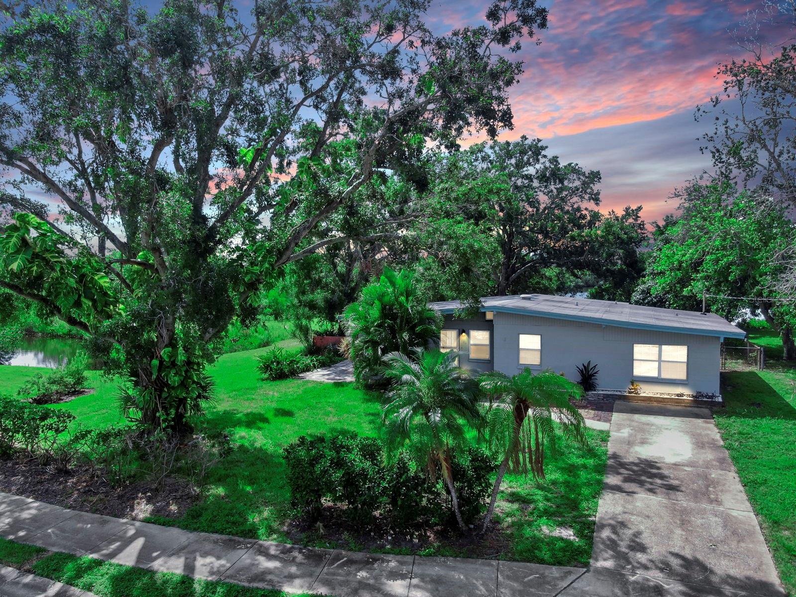 Discover a rare opportunity to reimagine this charming fixer-upper on a premium lot backing to a tranquil tidal pond, offering breathtaking water views and ultimate privacy in a quiet, low-traffic setting. Tucked away at the rear of the neighborhood, the property is enveloped by lush tropical landscaping, mature fruit trees, two mangoes, one orange one pomegranate. Along with expansive green spaces that invite outdoor living. The home, impacted by storm water, has been stripped to the studs in many areas, revealing its solid structure and providing a clean slate for customization—ideal for renovation enthusiasts or those seeking to build anew.
Inside, the open layout features striking exposed beams, multiple ceiling fans for comfort, and durable tile flooring throughout. Natural light floods the spaces through large windows and sliding doors, with highlights including a spacious living area, a functional kitchen ready for updates, and a modernized bathroom with stylish tile, a walk-in shower, grab bars, and contemporary fixtures. Additional rooms offer flexibility for bedrooms or home offices.
Outside, the generous yard extends to a scenic pond, enhanced by a brick paver patio, a built-in fire pit for gatherings, and a detached shed for storage. The driveway provides ample parking, and the serene environment is perfect for relaxation or entertaining. You're only a short stroll from Bicentennial Park and the Mobbly Bayou Wilderness Preserve. Seize this chance to craft your ideal oasis in a peaceful, nature-inspired location.