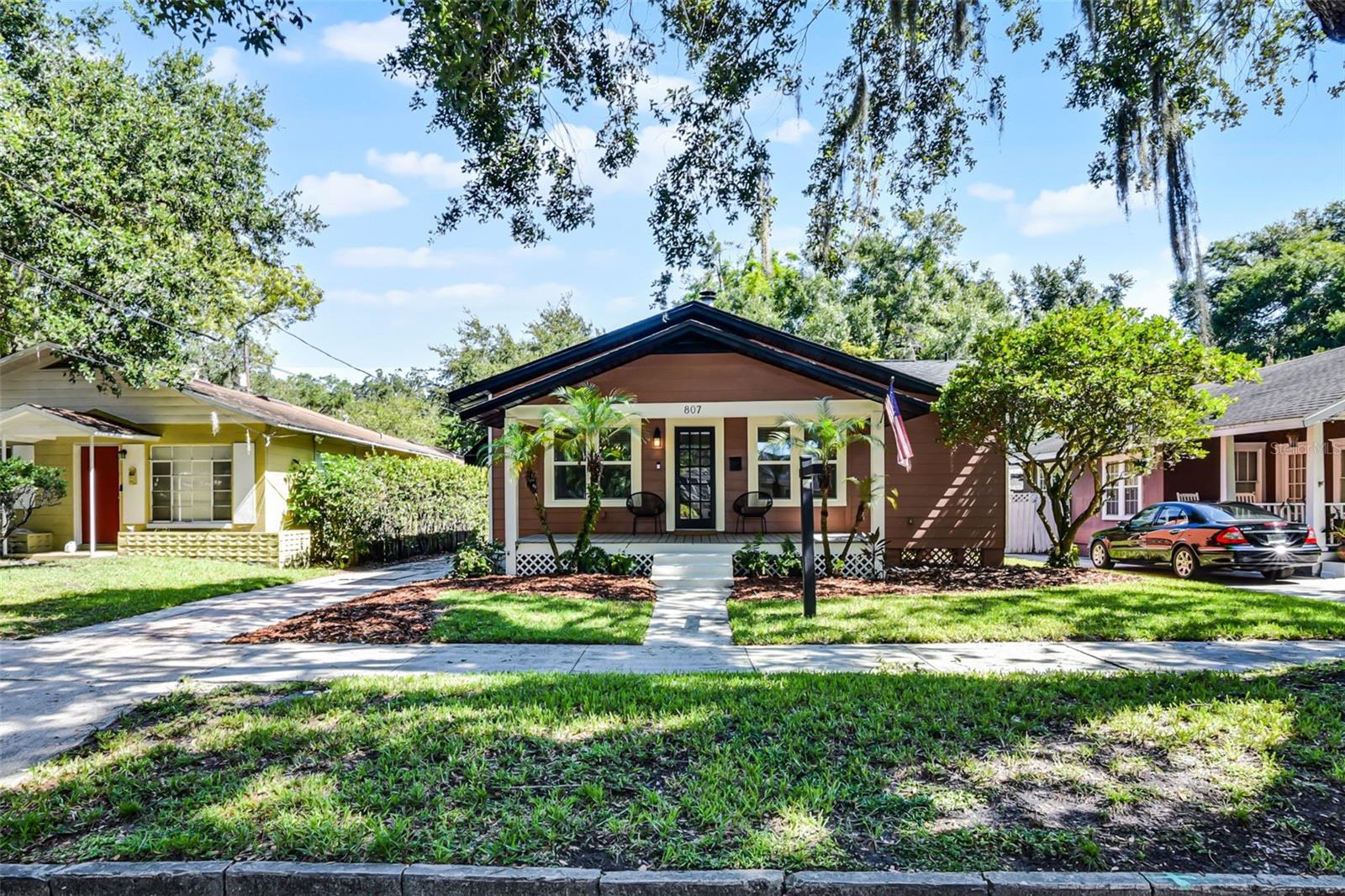 Welcome to your beautifully restored 1920s dream home in the highly sought-after Lake Davis/Greenwood neighborhood, just steps from the heart of Downtown Orlando and the charm of Thornton Park. Nestled on a picturesque brick-paved road just outside a designated historic district, this residence blends timeless character with modern updates. A brand-new front porch added in 2022 invites you to slow down and sip sweet tea while watching the world go by. Inside, you’ll find newly installed hardwood flooring flowing seamlessly throughout, complemented by elegant crown molding and a cozy fireplace that serves as the living room’s charming focal point. The updated kitchen features stainless steel appliances—including a brand new refrigerator, gas range, and vent hood—along with butcher block countertops and a generous pantry. The spacious owner’s suite offers a walk-in closet and private ensuite bathroom, while the two additional bedrooms share a stylish Jack-and-Jill bathroom. Step out back into your private oasis, complete with a pavered patio and oversized shed perfect for extra storage or a hobby space. Endless updates include a newer roof (2022), windows (2023), Water Heater (2020), electrical updates (2022), and a new washer and dryer that will convey with the sale—along with a Ring camera for added peace of mind. Enjoy the best of Orlando living with no HOA and unbeatable proximity to Lake Eola, Delaney Park, 903 Mills Market, SoDo, the Dr. Phillips Performing Arts Center, Kia Center, Orlando City Soccer matches, Camping World Stadium, and more. Zoned for Blankner K-8 and Boone High, this gem is the total package. Come fall in love with where history meets modern comfort—this one won’t last!