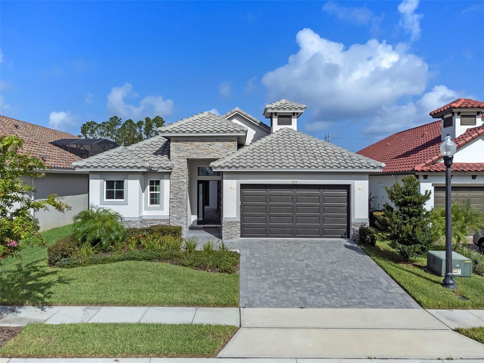 Located in the sought-after guard-gated community of Providence, this turnkey custom home delivers a perfect blend of modern design, smart technology, and relaxed Florida living. Completed in 2023, the home was designed with style, comfort, and efficiency in mind—perfect for those seeking a refined, move-in-ready lifestyle. Outdoors, unwind in the tranquil courtyard with a sparkling pool and spa combo surrounded by calming waterfalls. This relaxing space is also pre-plumbed and ready for your future outdoor kitchen—ideal for entertaining under the Florida sun. Every inch of this home was thoughtfully crafted for both comfort and sophistication, from the high-end finishes to the private courtyard oasis. A detached guest suite near the front of the home offers privacy and its own full bath with pool and garden views—perfect for guests, in-laws, home office or man cave. The heart of the home is the open-concept kitchen and living space—perfect for everyday living or entertaining. A sleek chef’s kitchen showcases quartz countertops, a large island with breakfast bar seating, premium stainless steel appliances and 42” soft-close shaker cabinetry with under-cabinet lighting. The entire main living area is finished with stylish tile flooring and features an electric fireplace that anchors the living room with warmth and charm. Luxury touches continue throughout with 8’ solid core interior doors, modern crown molding, flat wall finishes with square corner beads, and grooved baseboards. Wood-trimmed window sills add character, while smart features like Lutron switches and a whole-home smart hub elevate functionality. Built for efficiency, the home includes a heat pump HVAC system, R-30 insulation, and durable concrete block construction. The spacious primary suite offers a peaceful retreat with direct access to the courtyard and pool, plus a spa-like bathroom featuring dual vanities, frameless glass shower, rain and handheld fixtures and LED-lit mirrors. As a resident of Providence, you’ll enjoy access to top-tier amenities including a championship golf course, clubhouse with dining, resort-style and lap pools, tennis courts, a modern fitness center, dog parks, and scenic walking and biking trails. Recognized for its excellence in community design, Providence is where luxury living meets everyday ease. Don’t miss the opportunity to make this one-of-a-kind home yours.