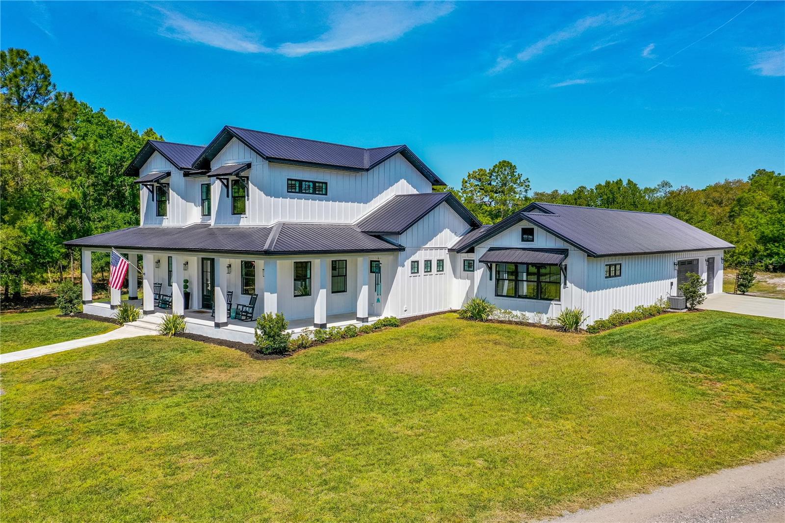 Welcome to this extraordinary farmhouse estate, nestled on 7.9 acres in the private gated community of Tallacoe Farms. This custom-built masterpiece features 3,920 sq. ft. of exquisite living space, seamlessly blending elegance and comfort. Step inside to soaring ceilings and an open-concept design that showcases designer finishes, a chef's kitchen with top-of-the-line appliances, and a grand living area with a statement fireplace. Enjoy resort-style outdoor living with a covered patio overlooking the sparkling pool with a Megaview screen enclosure. As the sun sets, the exterior lighting transforms this beautiful home into a breathtaking nighttime oasis. Thoughtfully placed architectural lighting highlights the home's grand façade and outdoor entertainment areas, creating a warm and inviting ambiance. Do not hesitate to schedule a private showing today!