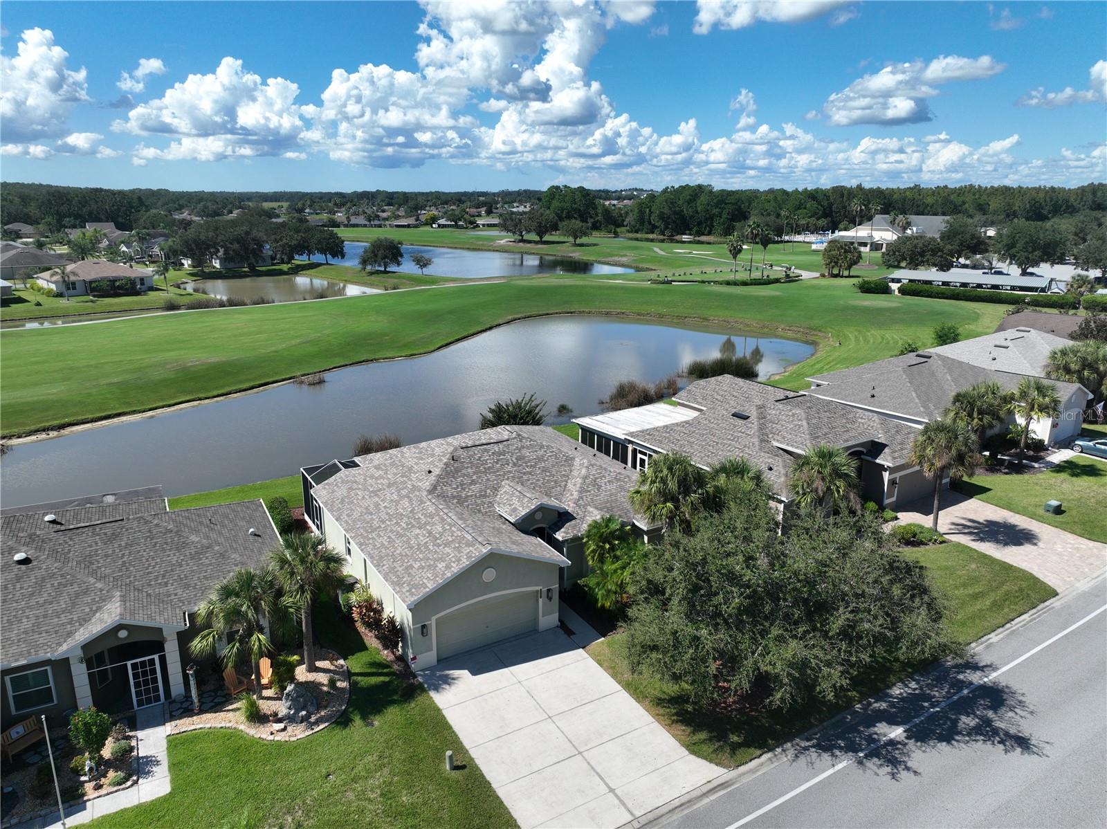 Beautiful Golf Course & Pond Views. Located in the sought-after 55+ community of Tampa Bay Golf and Country Club, this 3-bedroom home combines modern updates with stunning outdoor scenery. Step inside through a decorative glass front door into a spacious great room with 9.5-foot ceilings. Two sets of tinted sliding glass doors open to an oversized screened lanai with panoramic views of the pond and 10th hole. The kitchen has been recently remodeled with stainless steel appliances, quartz countertops, glass-tile backsplash, abundant cabinetry, pantry, and a dine-in area. The primary bedroom suite offers two closets, including an extra-large walk-in, plus a tiled shower with frameless glass enclosure and a relaxing whirlpool tub. The guest bathroom features a striking glass bowl sink with matching vanity cabinet. Updated light fixtures and ceiling fans add a modern touch throughout. Common rooms and wet areas have tile floors while bedrooms all have a matching luxury vinyl that complements the tile. The laundry room off the kitchen offers a stacked washer/dryer, utility sink, and broom closet for added convenience. Major updates include a new roof (2021), A/C (2019), and a tankless water heater for instant hot water. Enjoy access to resort-style amenities including two golf courses, swimming pools, fitness center, pickleball and tennis courts, and an on-site restaurant. HOA Fees include Cable, Internet, and Lawn Care. This home offers a low-maintenance, amenity-rich lifestyle with one of the best views in the community.
