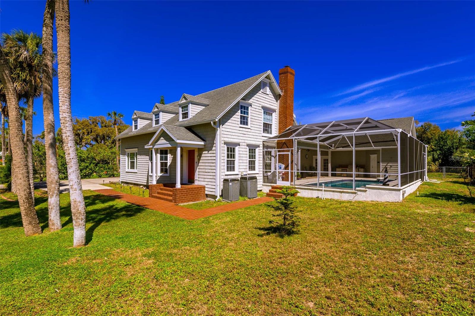 This exceptional property offers a rare chance to own a home that beautifully blends historic charm with modern conveniences, all situated on a generous 0.81-acre estate lot on John Anderson Drive. In 2006, the current owners undertook a large expansion and modernization of the property (adding nearly 2000 feet of living area), making this the perfect family home with great flexibility for those who like to entertain. Included in the new design is a large eat-in kitchen featuring custom cabinetry, granite countertops, and stainless steel appliances including a gas cooktop, range hood, double oven, warming drawer, wine fridge and dishwasher. Next to the kitchen is a formal dining room, or use it as a family room with beautiful oak floors, a gas fireplace and lovely pool views. The great room is an ideal space for family activities or perhaps a game or media room. The adjacent formal living area features immaculate oak floors and mahogany bookshelves creating a warm inviting space, flanked by a cozy den, complete with a wood-burning fireplace. The main level also features a spacious bedroom with a full en-suite bathroom, along with a half bath for guests.The second level offers a second primary bedroom plus three additional bedrooms, all boasting beautiful heart pine floors, adding to the home's historic appeal. A bonus room off the kitchen could serve as an office, exercise room or flex space with attached full bath that serves the pool as well. A large mudroom and laundry area lead out towards the oversized 2-car garage, with an EV charging station and attached workshop. Step outside to relax and enjoy the cool ocean breezes as well as the views of the expansive front lawn while sitting on the pool deck with built-in summer kitchen, or enjoy a swim in your pool with spa.This home is located less than a mile from Granada Boulevard, the Casements and Fortunato Park, and minutes more to all of the shopping, dining, and cultural events Ormond Beach has to enjoy.