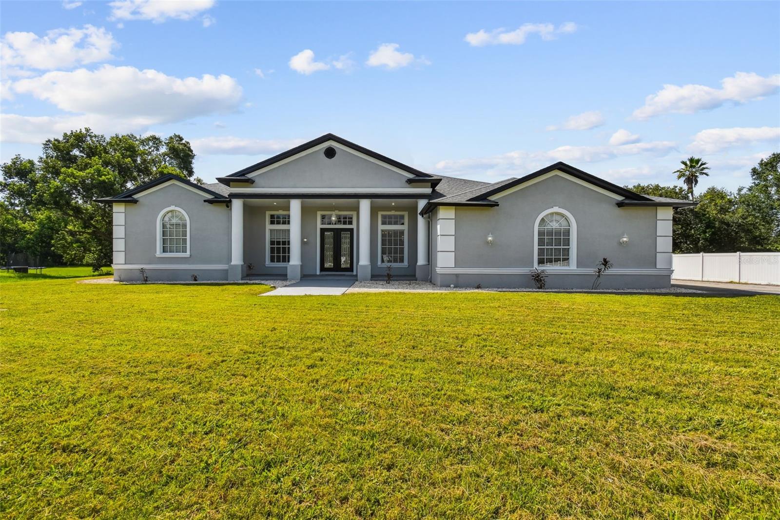 *BRING ALL OFFERS* *SELLER FINANCING AVAILABLE* ***Check Out The 3D Virtual Tour*** Welcome to your New FULLY Renovated, 3+ Bedroom / 3.5 Bath Custom Built Waterfront Executive dream home, on an expansive nearly 2 Acre lot. A masterpiece of design and Craftsmanship nestled in a prestigious location. Freshly Painted, Inside & Out! Spanning an impressive 3,578 square feet, this property is designed to cater to the eclectic tastes of modern-day homeowners, offering both the tranquility of a private retreat and the perfect backdrop for sophisticated entertaining. It is a beacon of elegance and comfort seamlessly blended to create an unparalleled living experience. As you step through the elegant double glass doors, the formal foyer welcomes you into a realm of refined beauty, setting the stage for the delights that lie beyond. The formal living room, with its poised ambiance, is ideal for hosting distinguished guests. In contrast, the expansive family room becomes the heart of the home—a place where families can gather and create memories. The room's telescoping sliders open seamlessly to a screened lanai that hosts a remarkable 12-person spa, marrying indoor luxury with outdoor serenity. The chef-inspired kitchen is nothing short of a culinary paradise, boasting 28 solid wood cabinets that provide ample storage space. Stainless steel appliances gleam under recessed lighting, enhancing the joy of cooking. A Separate island with a prep sink and breakfast bar allows for casual dining or effortless entertaining. Adjacently complimented by built-in bench seating dining area boasting panoramic windows for meals served with a view. Retreat to the master suite, a haven within this splendid home, featuring direct lanai access for private enjoyment of early morning or late-night serenity. Walk-in closets and a storm room/safe room provide peace of mind and convenience. The en-suite master bath offers an oasis-like atmosphere with dual sink areas and a sumptuous tub beside a walk-in shower for ultimate relaxation. Two additional bedrooms ensure comfort for family or guests alike, each with spacious bathrooms and walk-in closets. Beyond these personal quarters, this home features practical amenities such as a laundry room equipped with built-in cabinets and utility sink; an over-sized 3+ car garage with workshop space; and architectural details like high ceilings adorned with crown molding, plantation blinds, custom window inserts, decorative columns that enrich its aesthetic appeal. Massive driveway capable of accommodating multiple vehicles— underscoring its readiness to host gatherings large or small. Take a stroll down your own private sidewalk to enjoy some fishing in the Pond. With NO HOA, NO CDD, & No Deed Restrictions you can bring all your Boat, RV, & Toys. Nestled in the coveted locale of Country Club Road in Wesley Chapel, this residence stands as a testament to luxurious living where every detail is curated to foster an atmosphere of both grandeur and warmth. With its thoughtful design and opulent amenities set against the canvas of its desirable setting, this home invites you to embrace a lifestyle where comfort meets elegance in perfect harmony.
*Property being sold as-is, with right to inspect. Owner never occupied. Irrigation & Spa systems disconnected; never used and not warranted. (Brand new roof and HVAC already installed, with warranty)
***Check Out The 3D Virtual Tour***
One or more photo(s) has been virtually staged.