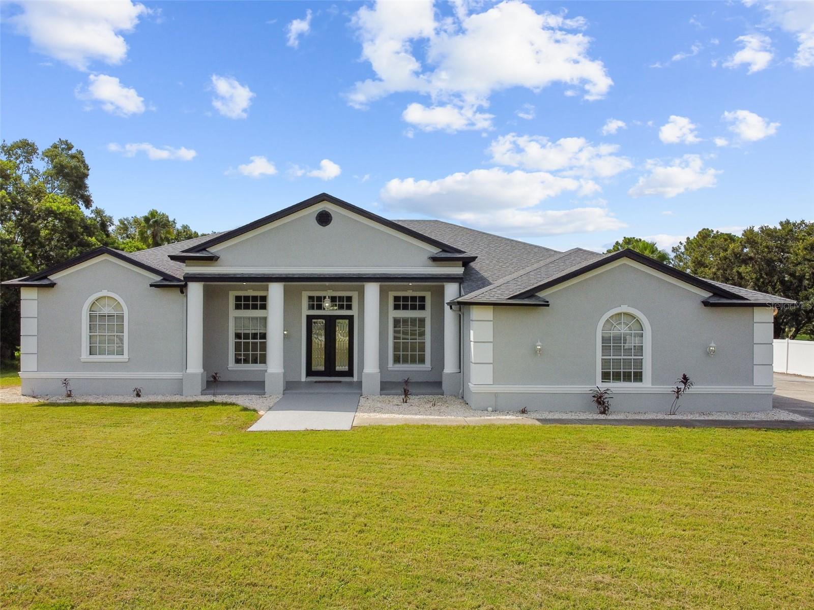 *SELLER FINANCING* ***Check Out The 3D Virtual Tour*** Welcome to your New FULLY Renovated, 4+ Bedroom / 3.5 Bath Custom Built Waterfront Executive dream home, on an expansive nearly 2 Acre lot. A masterpiece of design and Craftsmanship nestled in a prestigious location. Freshly Painted, Inside & Out! Spanning an impressive 3,578 square feet, this property is designed to cater to the eclectic tastes of modern-day homeowners, offering both the tranquility of a private retreat and the perfect backdrop for sophisticated entertaining. It is a beacon of elegance and comfort seamlessly blended to create an unparalleled living experience. As you step through the elegant double glass doors, the formal foyer welcomes you into a realm of refined beauty, setting the stage for the delights that lie beyond. The formal living room, with its poised ambiance, is ideal for hosting distinguished guests. In contrast, the expansive family room becomes the heart of the home—a place where families can gather and create memories. The room's telescoping sliders open seamlessly to a screened lanai that hosts a remarkable 12-person spa, marrying indoor luxury with outdoor serenity. The chef-inspired kitchen is nothing short of a culinary paradise, boasting 28 solid wood cabinets that provide ample storage space. Stainless steel appliances gleam under recessed lighting, enhancing the joy of cooking. A Separate island with a prep sink and breakfast bar allows for casual dining or effortless entertaining. Adjacently complimented by built-in bench seating dining area boasting panoramic windows for meals served with a view. Retreat to the master suite, a haven within this splendid home, featuring direct lanai access for private enjoyment of early morning or late-night serenity. Walk-in closets and a storm room/safe room provide peace of mind and convenience. The en-suite master bath offers an oasis-like atmosphere with dual sink areas and a sumptuous tub beside a walk-in shower for ultimate relaxation. Two additional bedrooms ensure comfort for family or guests alike, each with spacious bathrooms and walk-in closets. Beyond these personal quarters, this home features practical amenities such as a laundry room equipped with built-in cabinets and utility sink; an over-sized 3+ car garage with workshop space; and architectural details like high ceilings adorned with crown molding, plantation blinds, custom window inserts, decorative columns that enrich its aesthetic appeal. Massive driveway capable of accommodating multiple vehicles— underscoring its readiness to host gatherings large or small. Take a stroll down your own private sidewalk to enjoy some fishing in the Pond. With NO HOA, NO CDD, & No Deed Restrictions you can bring all your Boat, RV, & Toys. Nestled in the coveted locale of Country Club Road in Wesley Chapel, this residence stands as a testament to luxurious living where every detail is curated to foster an atmosphere of both grandeur and warmth. With its thoughtful design and opulent amenities set against the canvas of its desirable setting, this home invites you to embrace a lifestyle where comfort meets elegance in perfect harmony.
*Property being sold as-is, with right to inspect. Owner never occupied. Irrigation & Spa systems disconnected; never used and not warranted. (Brand new roof and HVAC already installed, with warranty)
***Check Out The 3D Virtual Tour***
One or more photo(s) has been virtually staged.