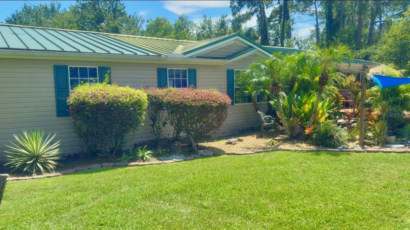 Country living at its finest, yet only a mile to EVERYTHING in Wesley Chapel. This home is situated on nearly 2 lush acres with a private forest to the rear and features three bedrooms with two bathrooms. Surrounding the back of the home is a large fenced in yard—perfect for dogs! Attached to the back screen enclosed/covered porch are five connected custom catios—perfect for cats or other sweet animals. Catios will be removed upon request. Both front and rear entries have long extended ramps for convenience. Rear and front porches provide a serene retreat for relaxation and privacy. Upon entering this hidden diamond in the rough property, you will notice the gorgeous custom tropical landscaping, and koi pond with waterfall. Open the outer door to enter the large front covered/screened porch. Enter the house to tall ceilings and large rooms. Family room and Living rooms are also large. There is a bonus den or 4th bedroom as well. The kitchen has been completely renovated and updated to a gourmet kitchen with all the best appliances. The MBR has an attached bathroom, this bathroom is a dream come true and was meticulously designed with custom wall treatments and accents. It offers both roman tub and shower, with double sinks and plenty of counter room. LOTS of storage room and comes with THREE SHEDS as well. A fourth houses the water softener. The owners have spared no expense, and maintained the home in top condition, with wonderful appeal. Even all of the original paperwork and warranties were preserved. AC only 2 years old. Hot water heater 4 years old. Roof 7 years old. Worried about storms? No need. The home is raised above the ground on a hill and suffered no flooding ever. Perfect for a relaxing zen like atmosphere and not requiring long drives to HWY 54 and I-75. This one is unique, and won't last long, so hurry to tour it today!