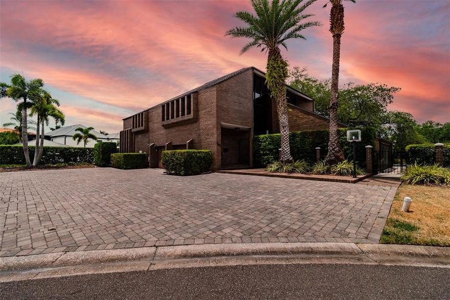Elegance and tradition are presented by this rare mid-century modern brick estate home. Located on a wide canal waterfront lot, in the gated South Tampa community of Culbreath Isles. The property is ideally situated for an end-user seeking a premium location, water-frontage and timeless architecture.  Enter the residence to be greeted by natural light, volume ceilings and a gorgeous staircase.  Grand floor to ceiling windows, notice many of the transitions touched by Frank Lloyd Wright inspiration, allowing the exterior to blend with the interior.  Design elements such as exposed interior brick flooring, creative wall space and complimentary lighting, focus and attention to the waterfront view and much more.  Beyond the entryway, the first floor offers a generous formal living room, separate dining room, study and eat-in kitchen.  Enjoy time together in the family room with access to the pool, a full bathroom, wet bar and loft.  The second floor offers four comfortable bedrooms including a massive owners suite.  With 133 feet of seawall, there is also a concrete dock, stairs into the canal and room for a potential boat lift.  From the home, it is a quick unencumbered navigation to the bay by boat.  The lot maximizes the water frontage, has plenty of irrigated green space and mature landscape with landscape lighting.  The pool patio offers plenty of space to create outdoor living while enjoying a view of the canal.  This estate is an art connoisseur’s canvas waiting to be slightly refined.