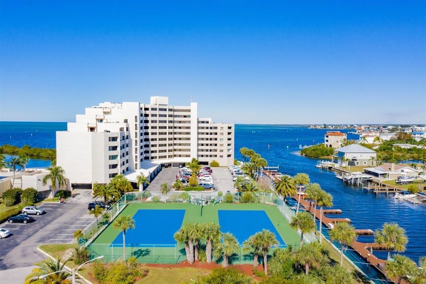 Welcome to a slice of paradise with unobstructed views of the Gulf of America from the 9th floor! Picture yourself on a 27ft balcony, gazing out at the crystal-clear waters, where dolphins and manatees gracefully swim by. Prepare to be captivated by the most breathtaking sunsets you've ever seen. This2-bedroom,2-bathroom condo has been fully remodeled with beautiful shiplap ceilings throughout, new stainless-steel appliances, quartz countertops and shaker cabinets. The entrance boasts an office/den that could easily transform into a third bedroom, adding flexibility to the living space. The heart of the home is a beautiful open kitchen/living area, strategically positioned to see panoramic views of the water. Sliding glass doors from both the living room and the master bedroom seamlessly connect the indoor and outdoor spaces, allowing you to soak in the coastal beauty. Safety and durability with hurricane-impacted windows and sliding glass doors providing peace of mind during stormy weather. The resort lifestyle extends beyond the confines of the condo, as the community has a plethora of amenities covered by the monthly HOA fee. A 24-hour gate guard and security ensure a sense of serenity, allowing you to fully embrace the relaxed atmosphere. Take a dip in the heated pool year-round, creating a perfect oasis even during the occasional colder months. For water enthusiasts, you have the option to rent personal boat slips, allowing you to explore the waterways at your leisure. Immerse yourself in the epitome of Florida's finest waterfront resort living, all at an extremely reasonable price. This is not just a home; it's an invitation to embrace a lifestyle where every day feels like a vacation! Don't miss the chance to make this dreamy coastal retreat your own!