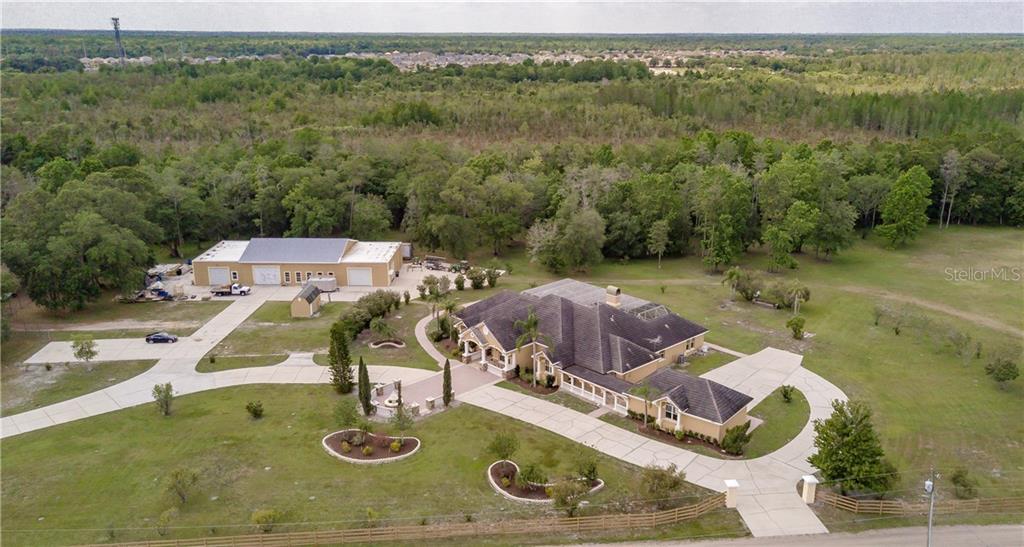 This stunning, custom designed and custom built home is a once in a lifetime opportunity. Imagine yourself driving in through the private gated entrance, past the serene pond, and up to the perfectly landscaped front yard. This home has all the little details you could ask for: crown molding, additional recessed lighting, built ins, study nooks, and many architectural touches throughout. Walk Into the formal living room with windows that let the Florida sunlight stream in. The spacious, open kitchen boasts both a bar with seating and an island for cooking. There is even an eating space between the kitchen and family room. You will always be part of the action as you show off your culinary skills. If you prefer to be more formal, there is a cozy dining room as well. The elegant master suite is the perfect get away including a built in space to relax and read. The en suite bath has dual vanities, a large, jetted garden tub, and separate shower. You may never want to leave. However, the game room may be calling you. Or the family room that has French doors leading to the oversized, covered and screened in lanai and pool. Perfect for entertaining or relaxing and soaking up the Florida sunshine. In addition to this over-the-top home, there is a separate workshop on property and additional land parcels included with this sale. Come and see for yourself. The opportunity to make this all yours won’t last long!