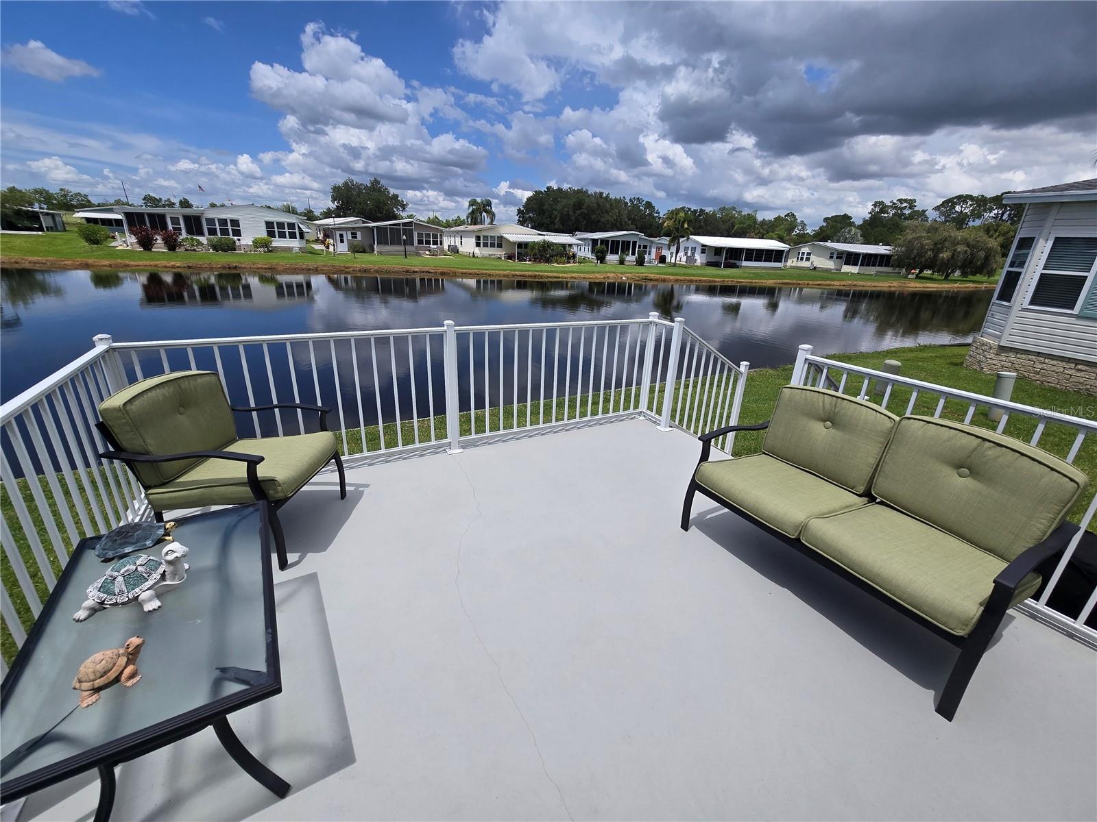 ON THE POND WITH A VIEW! Own your land and run your own life as this is a community owned by the residents and we make the decisions (I live here!) The HOA includes everything except your electric bill and lawn mowing! This beauty provides entertainment by all the nature you get a birds-eye view of from your kitchen, back patio, and the Florida Room. The floors are all laminate, the rooms are well sized, lots of storage with a pantry and 2 linen closets. The Primary Bedroom has an en suite and the closet is 4'deep! The bedrooms enjoy a split floor plan so everyone has more privacy. Laundry is in the kitchen by the dinette area. The Florida Room, on the AC, adds to your living space! The AC was replaced in 2017, the water heater in 2024, Main Roof in 2022 (vents redone in 2023), and the Florida room and carport roof was installed in 2023. This financially sound, gated golf community has structured itself to enjoy the good life! The golf cart is included so you are ready to enjoy the executive 18 holes golf course for just $5 green fees in this Gated, Golf Community, located just outside of the city, and approx. 1.25 hrs. from either coast. Great access to Disney, Legoland, and BOK Tower, just to name a few local attractions. In this very friendly, resident-owned community, you can be as active or inactive as you choose! Gatherings at the private Pub or the Community Room, fishing & boating on Lake Henry (dock within the community), gardening, tennis, golf, shuffleboard, pickle ball, horseshoes, swimming in the heated pool, enjoy the hot tub or the 24/7 workout room! Contact this community's website for documents, including Rules/Regs, Application, Financial, and Bylaws. HOA INCLUDES A DVR PLUS 2 HD CABLE BOXES AND INTERNET! (Minimum age in this 55+ community is 50 years old)