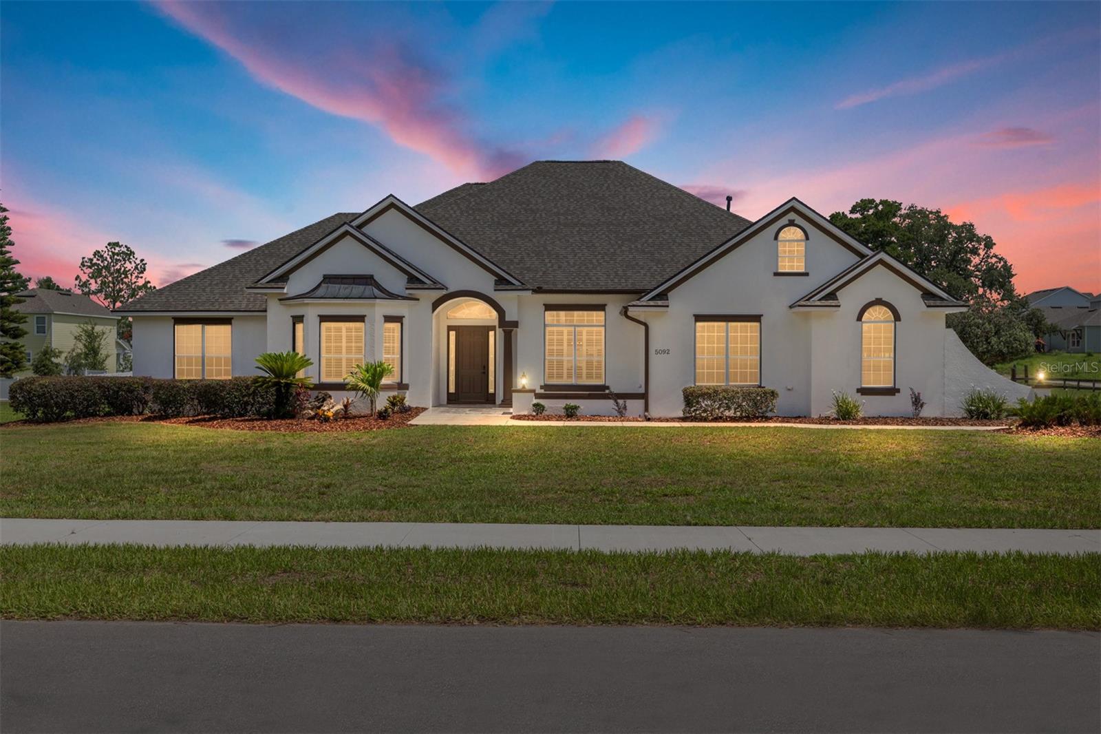 This magazine-worthy estate is the fusion of luxury, freedom and style—a fully reimagined three-bedroom, three-bath masterpiece offering 3,407 square feet of elevated living on a sprawling 2.28-acre parcel just 2.2 miles from The Brownwood Paddock Square. This homesite abuts the Villages. With no HOA, this former executive model home has room to build a detached garage, or dream workshop. It’s an uncommon opportunity to live expansively without restrictions—just minutes from world-class golf, shopping and dining. From the moment you go inside, you’re welcomed by gleaming tile flooring throughout the entry, kitchen, dining area and all remodeled baths, creating a seamless and elegant flow. The kitchen is a chef’s dream, featuring striking quartz countertops and new designer GE Café appliances, anchored by open sightlines and refined finishes. Every bath has been completely redone, showcasing custom tilework, upgraded lighting and premium Delta fixtures, while all new ceiling fans, stylish light fixtures, and fresh interior/exterior paint continue the upscale feel throughout. This home is loaded with top-tier mechanical upgrades, including a new 2025 roof, two new Trane HVAC systems 2025, a new water heater 2025 and newer fencing surrounding the freshly landscaped grounds. Go out back and you’ll find your private oasis, a sparkling pool, a new outdoor kitchen and full bath, and yes—a beer refrigerator that’s ready for your next backyard gathering. The attached garage includes a full-size workbench. With ample open space, a fully updated interior and room to expand your lifestyle, this home isn’t just move-in ready, it’s life-upgrade ready. Magazine worthy, builder friendly and entertainer approved, this one is the total package.