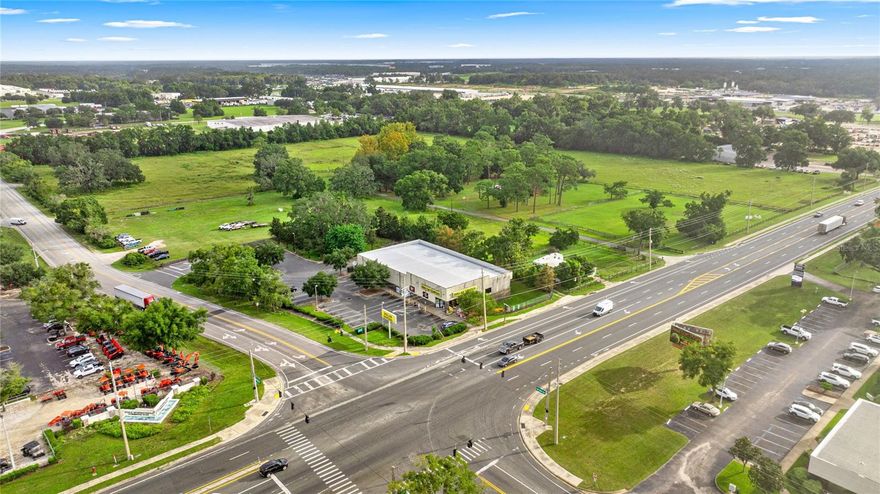 A rare opportunity to secure a large land tract with access via a signalized intersection at NW 52nd Ave just off of W Hwy 40! This 25.00 +/- acres of high-visibility land is currently being rezoned to M-1 Industrial. Parcel could be split into as low as 12 acres (+/-) or can be sold as the estimated 25 acre larger tract. Strategically located in one of Marion County’s most active growth areas, this exceptional site offers outstanding development potential.  With very close proximity to several large industrial developments like the Ocala Airport Commerce Park, the Ocala International Commerce Park, and Meadowbrook Industrial Park, the location is unmatched! With a premier location right in the main ‘’hub” of Ocala/Marion County’s most sought after location for large corporations seeking ease of transportation, available workforce, and economic growth, this parcel offers excellent opportunities for long term sustainability.
Truck access to the property is easy configurable, and there are no deed restrictions to the property.  Excellent proximity to the I-75 interchange at Hwy 40, as well as easy access to several other highly traveled roads through the booming Ocala area. The property features excellent access from W Hwy 40 (a major traffic artery), and is surrounded by extensive shopping, dining, and service amenities.  There is a City of Ocala Sewer Force Main adjacent to the property on NW 52nd Avenue , a Gravity Main, Manholes, and Sewer in the center on NW 52nd Avenue with laterals to the property. Additionally, a City of Ocala 16” Water Line is across NW 52nd Avenue with laterals in place to the property and hydrants located along NW 52nd Avenue. The area boasts strong demographics, above-average rooftop counts, and close proximity to a large of amount of both new and existing construction projects. With its combination of size, accessibility, and market exposure, this parcel is ideally suited for a landmark project in a high-demand location.