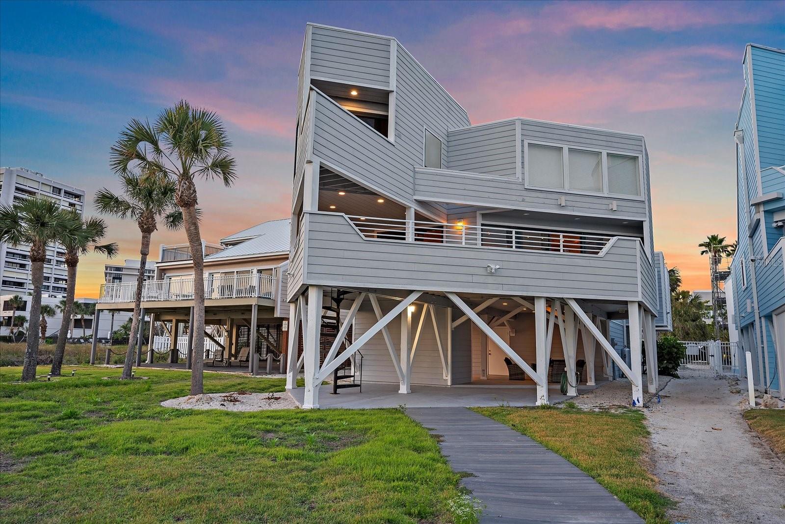 Nestled along the pristine sands of Siesta Key, this multi-level beach house is a true gem offering an idyllic coastal lifestyle. Immaculate and beautifully designed, the property boasts expansive decks that capture spectacular western views of the beach and the shimmering Gulf of Mexico. As you enter the home, you are greeted by a large living room that serves as the heart of this coastal retreat. The living room is adorned with a stunning rock fireplace, providing both warmth and a rustic charm. This space is perfect for cozy evenings with family or entertaining guests. Adjacent to the living room is a well-appointed wet bar, ideal for mixing cocktails or serving refreshments during gatherings. The open kitchen is a chef's dream, featuring ample counter space, and a layout that encourages culinary creativity. Whether you are preparing a quick meal or hosting a dinner party, this kitchen is equipped to handle all your needs. The dining area, situated next to the kitchen, offers a welcoming space for meals with loved ones. Large windows allow natural light to flood the space, creating a bright and airy atmosphere. One of the standout features of this home is the loft, which offers breathtaking views of Siesta Key beach. This elevated space provides a serene retreat where you can unwind, read a book, or simply take in the stunning vistas. The loft's strategic positioning ensures you have the best vantage point to enjoy the natural beauty that surrounds the property. The primary bedroom is a sanctuary of tranquility, featuring a spacious alcove perfect for a private office or a cozy reading room. This room is a haven for relaxation and productivity. The spa-inspired bathroom in the primary suite is a masterpiece of luxury. Equipped with dual sinks, a jetted tub, and a large shower, it offers a rejuvenating escape from the daily grind. The bathroom also includes a private balcony, providing a serene outdoor space to unwind. The additional two bedrooms are equally generous in size, offering ample room for family and friends. These rooms are designed to provide both comfort and functionality, ensuring that guests feel right at home. The expansive deck overlooking the seagrass and nesting turtles is a true sanctuary. This outdoor space is perfect for relaxing, sunbathing, or hosting al fresco meals. The sight of nesting turtles and the gentle sway of seagrass provide a tranquil backdrop, making the deck a favorite spot for residents and guests alike. The ground floor of the home includes a full bathroom and a lounging area, adding to the convenience and comfort of the property. Whether you are coming in from a day at the beach or entertaining guests, these amenities ensure that you have everything you need within easy reach. The oversized two-car garage provides ample space for your vehicles and additional storage. Whether you have multiple cars, or perhaps a boat or outdoor gear, this garage is designed to accommodate it all. Additionally, the large first-level workshop is perfect for those who enjoy hands-on projects. Equipped with plenty of space for tools and equipment, this workshop is an ideal space for carpentry, crafting, or any other hobbies you may have. This beachfront home is not just a property; it's a gateway to a lifestyle enriched by nature, luxury, and community. Whether you are looking for a permanent residence or a vacation home, this property promises an exceptional living experience that is truly unparalleled.