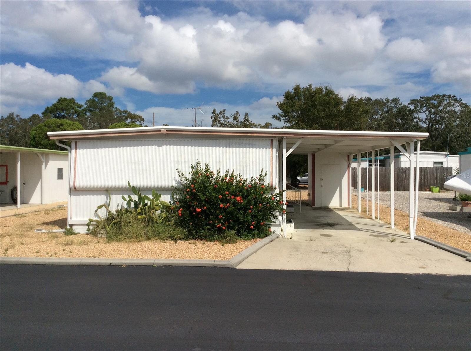 Tiki Village, a 55-plus gated Community. Featuring two-bedroom, two-bathroom, and one-car built-in carport. Glass enclosed Florida Room. It includes a detached shed with washer/dryer hook-up. The property has a low annual $420.00 HOA fee. TAT civic association offers membership to Tiki Village MHP, pool membership, RV storage and boat parking. Mobile home is being sold in "as-is" condition. Sellers have never occupied the property. Mobile home was not impacted by Hurricane Helene.