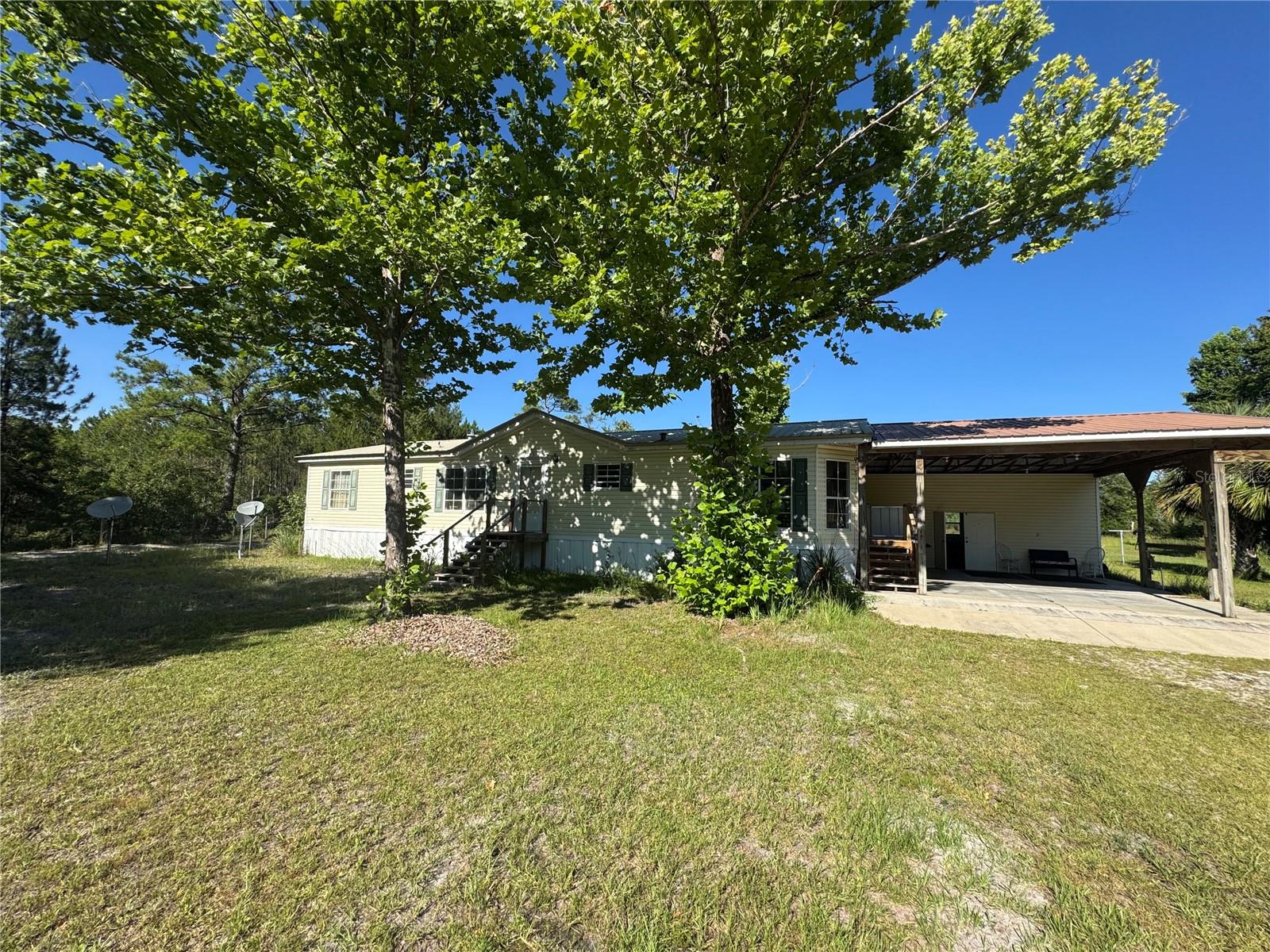 Peaceful Country Living on 20 Acres – Outdoor Adventure Awaits in Chiefland, FL! Welcome to your private outdoor paradise! This well-maintained 3-bedroom, 2-bath 1999 double-wide manufactured home is nestled on a stunning 20-acre property in Chiefland, FL—featuring 10 acres of wooded land ideal for hunting, and directly adjacent to the Lower Suwannee National Wildlife Refuge, offering unmatched access to outdoor exploration and wildlife. Inside, the home features a bright and spacious open floor plan, with a well-equipped kitchen offering ample cabinetry and generous counter space—perfect for everyday cooking or entertaining guests. The primary suite serves as a relaxing retreat with a walk-in closet, dual sinks, a vanity area, and a large step-in shower. The laundry room is located outdoors in a convenient covered space, and the home is also equipped with a water softener system and electric lift, offering comfort and accessibility. Step out onto the oversized 12x24-foot back porch, ideal for morning coffee, evening sunsets, or watching deer wander the back acreage. Outside, the land offers the best of both worlds: wide-open green space, a scenic pond, and wooded acreage perfect for hunting, exploring, or building trails. A large green barn is perfect for storage, a workshop, or your favorite hobbies. There’s even dedicated RV parking, ready for guests or your next road adventure. The location is a dream for outdoor lovers Just minutes to Treasure Camp on the Suwannee. Bordering the Lower Suwannee National Wildlife Refuge, Near Shell Mound boat ramp, A short drive to charming Cedar Key and Manatee Springs State Park. Whether you're an avid hunter, a nature lover, or simply seeking peace and space to roam, this unique property has it all. Don’t miss this opportunity—schedule your private tour today and experience the best of North Florida country living!