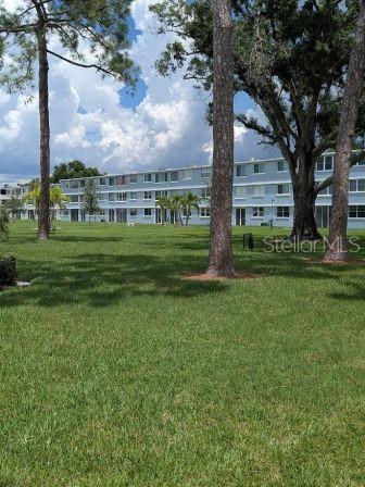 Beutiful open view of manicured grounds and mature trees. Carport at door.