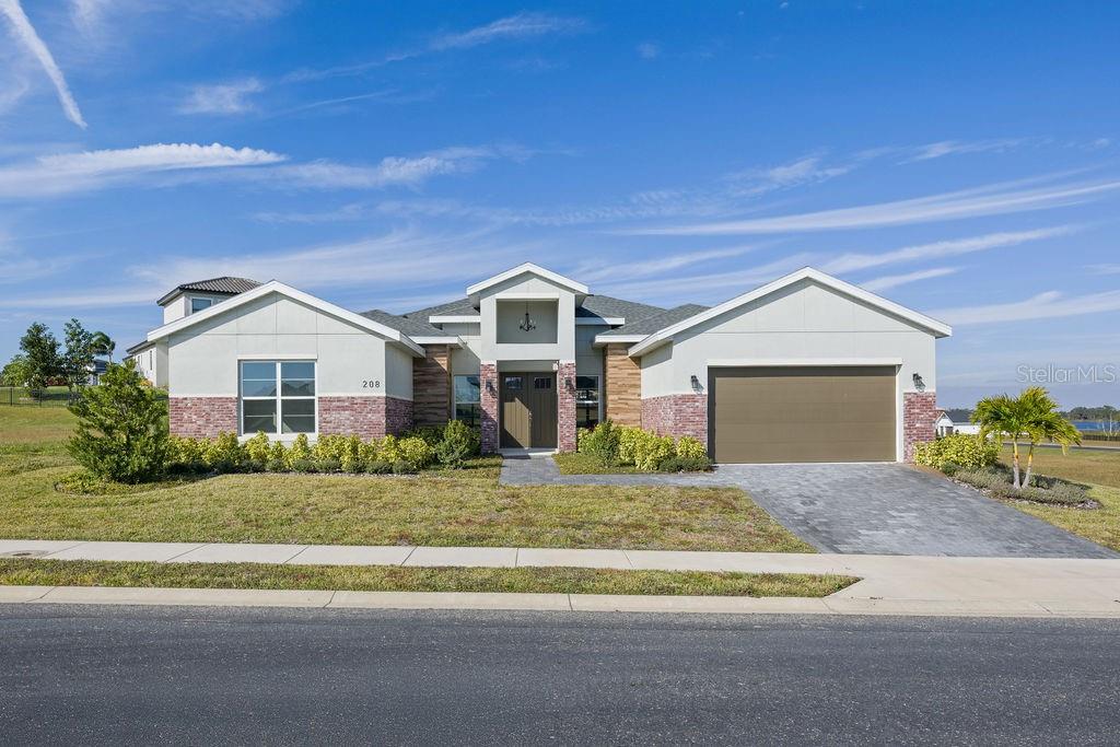 JUST REDUCED OVER $40,000. Welcome to the exclusive Water Ridge community where you will be allowed to escape the hustle and bustle of city life and relax with beautiful lake views and breathtaking sunsets. As soon as you walk into this home, you are welcomed by natural light that overflows from its many windows and the grandeur sensation provided by your 10-, 12- and 14-foot ceilings. You’ll enjoy the open floor plan that allows you to move with ease from the foyer to the living room and the kitchen, making your family gatherings even more memorable. Your kitchen features granite countertops, granite backsplash, stainless steel appliances, 42-inch cabinets with slow-close features and a massive walk-in pantry. Continuing through the home, you arrive at the primary suite that is equipped with 10- and 12-foot tray ceilings. The primary bath features a walk-in shower, huge walk-in closet dual sink vanity, ample storage space and a beautiful freestanding tub ideal for a quiet evening of relaxation. In addition, the home features three spacious guest bedrooms that are on the separate wing of the house, providing privacy to the owner's suite. Once done inside, it’s time to go outside and enjoy the Florida lifestyle! As a resident of this community, you have access to the community dock and boat ramp. The clubhouse with its fitness center, common area and tennis courts are all within a private gated community. And to top it off, you could not be in a better location between Tampa and Orlando. You’ll have easy access to major highways and be within a short drive to new retail developments. All that’s missing is you. Contact your REALTOR® today for a private showing. Competitive financing options available, including options for a rate buy down!