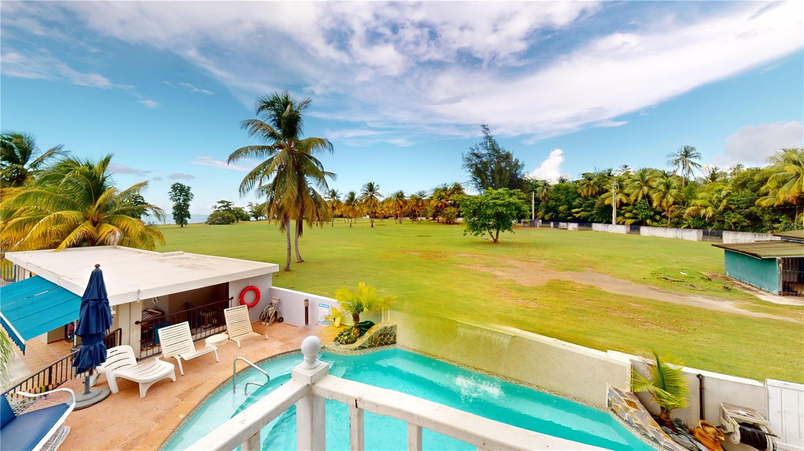 PALMA SOLA, Las Picuas, Rio Grande, Puerto Rico 5 Bedrooms · Ocean Front · Pool OFFERED AT: $2,400,000 Discover your Caribbean oasis in the quiet Las Picuas neighborhood, just five minutes from Rio Mar resort. Perfect for beach lovers, this oceanfront property is ideal for snorkeling, paddleboarding, fishing, and sailing. This solid, three-story concrete home features French doors, storm windows, roll-down security doors, a pool, patio with bar, and generator. The main house has five bedrooms and three bathrooms. The master suite has an ensuite bath, while the spacious kitchen/living area and media room provide comfort. The roof deck is built for entertaining, complete with a shaded area and bar. An oceanfront casita with a roof deck offers breathtaking Caribbean views. The gated property features a utility building with bathrooms, storage, and lush tropical landscaping.