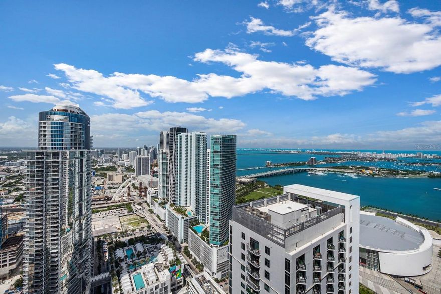Welcome to Natiivo Miami, a premier luxury high-rise in the heart of Downtown. This 2-bedroom, 2-bath residence on the 51st floor offers 907 sq ft of modern living space with floor-to-ceiling windows and a private balcony showcasing breathtaking views of Biscayne Bay and the city skyline. Designed with an open floor plan, smart home features, stone counters, and sleek finishes throughout, this condo combines style and convenience. Residents enjoy world-class amenities including a resort-style pool deck, fitness center, 24-hour concierge, valet service, and on-site dining. Located steps from Bayfront Park, the Kaseya Center, and vibrant arts and entertainment venues, this home offers the ultimate Miami lifestyle.