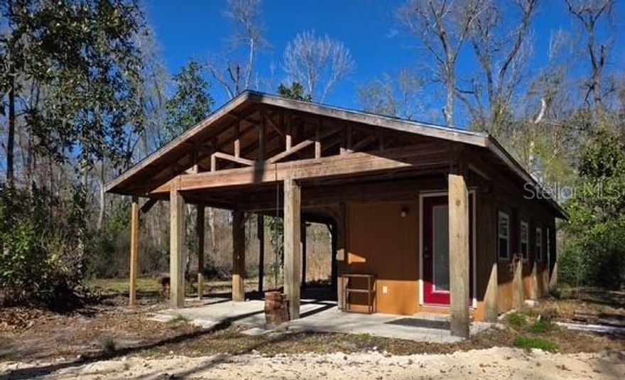 Rare opportunity - Own 4 adjoining lots with 3 wells, power, 4 septic systems & 3 RV power hookups.  One lot has a tiny house designed for simple living with a full bathroom & is set up for an outdoor kitchen.  Hand pump installed so water is available even when the power goes out.  There is also a 12’ x 12’ shed with window AC unit for an additional tiny house experience.  Each lot has power, septic system, well & RV connection.  The land has been cleared around the living quarters but otherwise left naturally wooded adding to the beauty & privacy of rural living.  Enjoy watching the colorful sunsets & abundance of wildlife while beginning your day or unwinding on the front porch.  With $175.00 yearly fee, enjoy golf carting to the multiple neighborhood parks including 13 private parks & boat ramp accessing the Santa Fe River & Ichetucknee River. 
Wonderful opportunity for a family compound, income or just a great place to call home.  Additional vacant lots available see GC538105 & GC538112 (totally 6 contiguous lots).