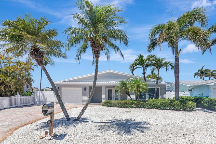 BIG PRICE IMPROVEMENT! Location, Location, Location!! Beautiful fully renovated WATERFRONT home in North Redington Beach featuring 2 bedrooms 2 baths and over 1500 sq/ft of living space with an OPEN FLOOR PLAN. Nearly everything is BRAND NEW! NEW PAINT inside and out! NEW AC. All new laminate plank flooring throughout. All new kitchen with quartz counters and backsplash, upgraded cabinets and drawers with soft close, crown molding, LG stainless steel appliances and wine cooler. Spacious primary suite featuring walk in closet with built in custom closet system. Upgraded primary bathroom with dual sinks and walk in shower. All new doors and light fixtures throughout. Outside is a waterfront oasis featuring sweeping WATER VIEWS, brand new deck, a fire pit, tropical landscaping, and dock with 12,000lb boat lift. 1 car attached garage with brand new opener. Amazing location, walking distance to the soft white sand beaches of the GULF. Group Flood Insurance Policy INCLUDED until 11/27/27 at no cost to buyer! This home feels like it's BRAND NEW and is ready for it's new owner. One or more photo(s) has been virtually staged