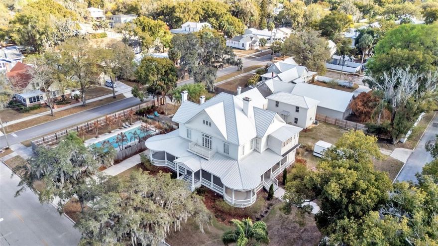 One or more photo(s) has been virtually staged. This exquisite Victorian-style residence, constructed in 1906 (reportedly by Polk County lawyer Thomas Lee Wilson), stands as a timeless architectural gem. Famously known as the My Girl house from the beloved 1991 film where it served as the exterior of the Sultenfuss family home. It has also graced history as the Stanford Inn Bed & Breakfast and, more recently, as His Hope House. 
The primary home spans approximately 5,776 square feet of air-conditioned living space, masterfully blending its rich historic charm with thoughtful, extensive renovations that honor and preserve its original character and elegance. Complementing the main residence, the
property features a charming separate one-bedroom guest house, an additional building currently utilized as versatile meeting and donation space, and a spacious, inviting pool. All set on beautifully landscaped grounds that enhance its enduring appeal. This captivating tour begins on the expansive 1,500+ sf wraparound porch; a perfect spot for entertaining, events, or quiet mornings with coffee. Inside, the grand foyer opens to elegant spaces: a front sitting room, formal living and dining rooms, a private office, and a beautifully updated kitchen with modern cabinetry, premium appliances, a large center island with bar seating, and a secondary dining area. Timeless features include wainscoting, new lighting, some original hardwoods, a sprinkler system, and remodeled period bathrooms. The main level offers a spacious primary suite with fireplace and full ensuite bath, two guest half baths, and first- floor laundry. Upstairs, a versatile loft area complements five additional bedrooms, each with unique charm, featuring fireplaces and private ensuites. Plus a second laundry for added
convenience, ideal for multi-generational or flexible living. The 1,000 sf two-story guest house (built 2022) includes a kitchen, living room, bathroom,upstairs bedroom, and loft space; perfect for guests or additional use. The remodeled former carriage house (third building) offers 500 sf with power, A/C, and space for offices, storage, or other needs. The property is zoned R-3, in the City of Bartow which offers tremendous future potential beyond its current configuration. This may include hospitality and short-term rentals (Bed and Breakfast or Airbnb capitalizing on its famous “My Girl” movie history), group or supportive living (family-care, maternity, residential program, hospice, rehab or similar), multi- generational or extended family estate, or Event space (host private events, retreats, small-scale commercial uses while maintaining residential charm). Verifying your use within the City of Bartow’s zoning uses. This historic gem blend of preserved Victorian elegance, modern updates, and adaptable layout positions it for endless possibilities, whether as a cherished family home, income-
generating venture, or meaningful community resource.
** Photos in the guest house have been virtually staged to illustrate the property’s potential **