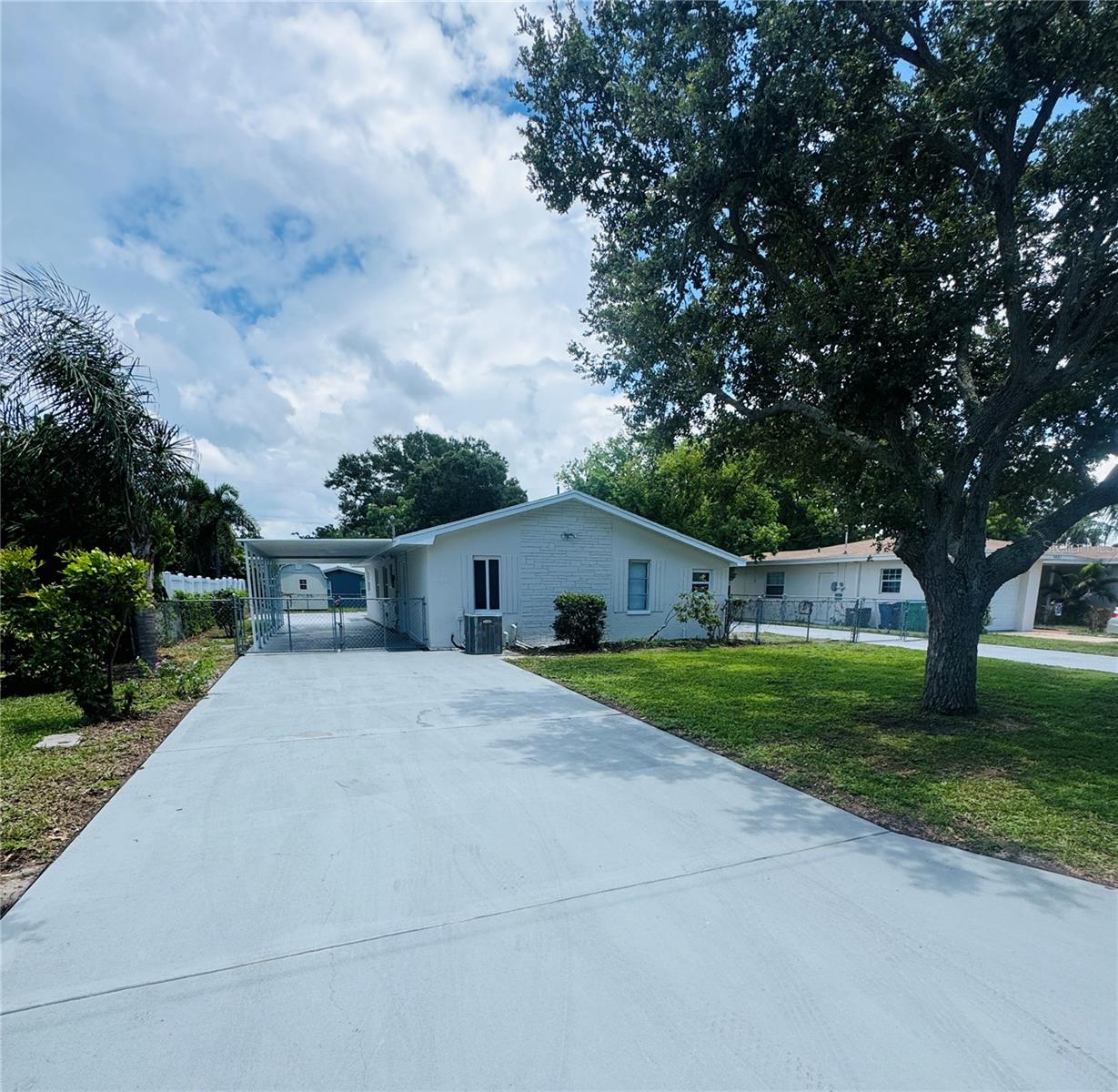 5 miles from the beach and not in a flood zone!? Sounds too good to be true but don't miss the chance to own this beautifully updated and unique home!! Turn-key ready with freshly painted exterior & interior, updated kitchen with brand new stainless steel appliances, new LVP flooring in bedrooms, and ceramic tile through the remainder of the home providing durability for years to come! Enjoy the ample parking with 2 separate driveways, one of which accommodates 3 cars in covered parking to keep things nice and cool on our hot Florida days! Completely fenced yard perfect for your furry friends! Need additional storage?? No problem. This home has not 1, not 2, but 3 separate storage rooms to meet all your needs! Sewer line replaced 2025, water heater 2022, AC 2016, and roof in 2013. Convenient to plenty of shopping and food destinations and the crystal blue waters of Indian Shores Beach.
