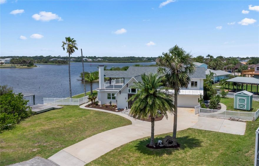 Experience the best of Florida living in this stunning two-story pool home, perfectly nestled on a spacious and private corner lot along a protected stretch of the Intracoastal Waterway. With your own boat lift and over 300 feet of waterfront, this home offers a rare blend of coastal charm, luxury, and convenience.

From the moment you arrive, you’ll be drawn in by the exceptional curb appeal and thoughtfully designed interior. Step inside to find custom kitchen cabinetry that blends style and functionality, a dramatic open staircase that adds architectural flair, and a striking Moroccan chandelier in the living room for a touch of exotic elegance.

The first-floor master suite serves as a peaceful retreat, featuring a beautifully updated en-suite bathroom with a freestanding soaking tub, dual vanities, and a spacious walk-in shower with elegant tile work, making it the perfect place to relax and recharge.
Upstairs, two generously sized bedrooms provide comfort and privacy for family or guests. Step out onto the second-floor deck—partially covered and ideal for morning coffee or sunset cocktails—while enjoying breathtaking panoramic views of the Intracoastal, where dolphins play and sailboats glide by.

Outside, the private pool invites you to unwind with stunning water views all around. Whether you’re entertaining or enjoying a quiet evening, this backyard oasis delivers unforgettable moments.