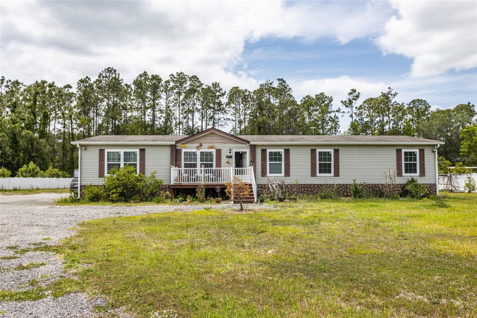 One or more photo(s) has been virtually staged. This well-maintained 4 bedroom, 2 bathroom manufactured home sits on a generous 1.14-acre lot, offering the perfect blend of comfort, functionality, and opportunity. Inside, you’ll find two spacious living rooms, ideal for entertaining or relaxing, and a large kitchen featuring a center island that's perfect for gatherings. Each bedroom includes a walk-in closet, providing ample storage for the whole family. Step outside to enjoy a large screened-in back porch overlooking an above-ground pool, creating a private oasis for summer fun. Need space for your hobbies or business? This property features two fully-equipped workshops! The first workshop is set up for serious work with lights, water, AC, and even a bathroom—ideal for running a business from home. The second workshop offers electricity and air conditioning, perfect for additional workspace, storage, or a creative studio. Whether you're looking to spread out, start a home-based business, or just enjoy peaceful country living, this property has it all!