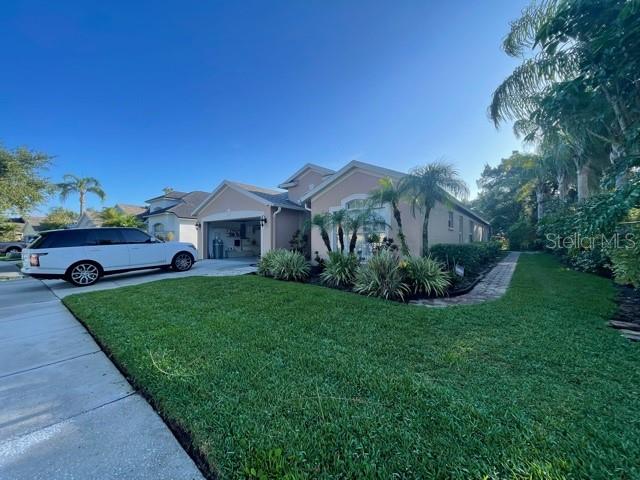 Beautiful 4 bedroom 2 bathroom 2 car garage corner lot Home in the Westchase area of Tampa, The mature landscaping is so inviting. Beautiful dramatic entrance as you walk through the lead glass door, with custom Travertine flooring and drop chandelier to greet you. Vaulted ceilings, architectural details galore, and custom light fixtures throughout add elegance to this open, spacious floor plan. Recessed lighting and tons of natural light to brighten your day! The gourmet kitchen features custom cabinets with crown molding, granite counters, decorative backsplash, built-in desk, and breakfast bar with room for seating. Stainless steel kitchen appliances include glass-top range, French door refrigerator with ice and water dispenser, microwave, and dishwasher. Pantry and linen closet keeps your essentials organized. Master bedroom features 2 walk-in closets with custom shelves and a full bath for privacy. The master bathroom boasts a custom double-vanity & sinks with granite counter top, garden tub, and walk-in shower. Carpet in the secondary bedrooms adds warmth and is so comfy on your feet. Ceiling fans will be sending you a cool breeze. Efficient central AC and heat will keep you comfy year round. Laundery room with washer and dryer CONNECTIONS for your convenience. Water softener is gentle on your clothes! Window blinds allow just the right amount of light. HUGE screen-enclosed paved patio, Convenient to Baybridge Park, Veterans Expy, Schools, and shopping, with groceries, retail, and restaurants near by.