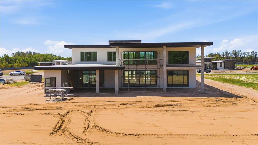 Under Construction. In the gated community of Odessa Preserve, The Milan delivers over 9,000 square feet of refined indoor-outdoor living across two levels. With two primary suites and expansive common spaces, this residence is thoughtfully designed for multigenerational comfort, entertaining and daily elegance. The entryway opens to a soaring two-story foyer with architectural sightlines that lead to the heart of the home, a central great room with formal dining and flanked by a den and dedicated playroom. A chef's kitchen and adjacent prep kitchen provide visual appeal and utility, while the rear lanai and cabana extend the living experience outdoors with covered lounging, a full summer kitchen and resort-style pool and spa. The first floor hosts a guest or secondary primary suite with direct lanai access, while the upper level features an additional primary suite with private balcony, dual vanities, soaking tub and walk-in shower. Three additional bedrooms with en suites and an optional bonus/theater room round out the second floor, designed to accommodate large or extended households with grace and flexibility. Garage space totals 1,627 square feet across two structures, allowing for up to five vehicles or collectible storage. The Milan is serviced by a whole-house generator and is prewired for security and home automation. Every element, from open-air balconies to climate-controlled wine storage, reflects the thoughtful sophistication Odessa Preserve is known for. Located just three miles from the Veterans Expressway and 20 minutes from Tampa International Airport, this estate pairs timeless design with modern accessibility in a private and prestigious setting.