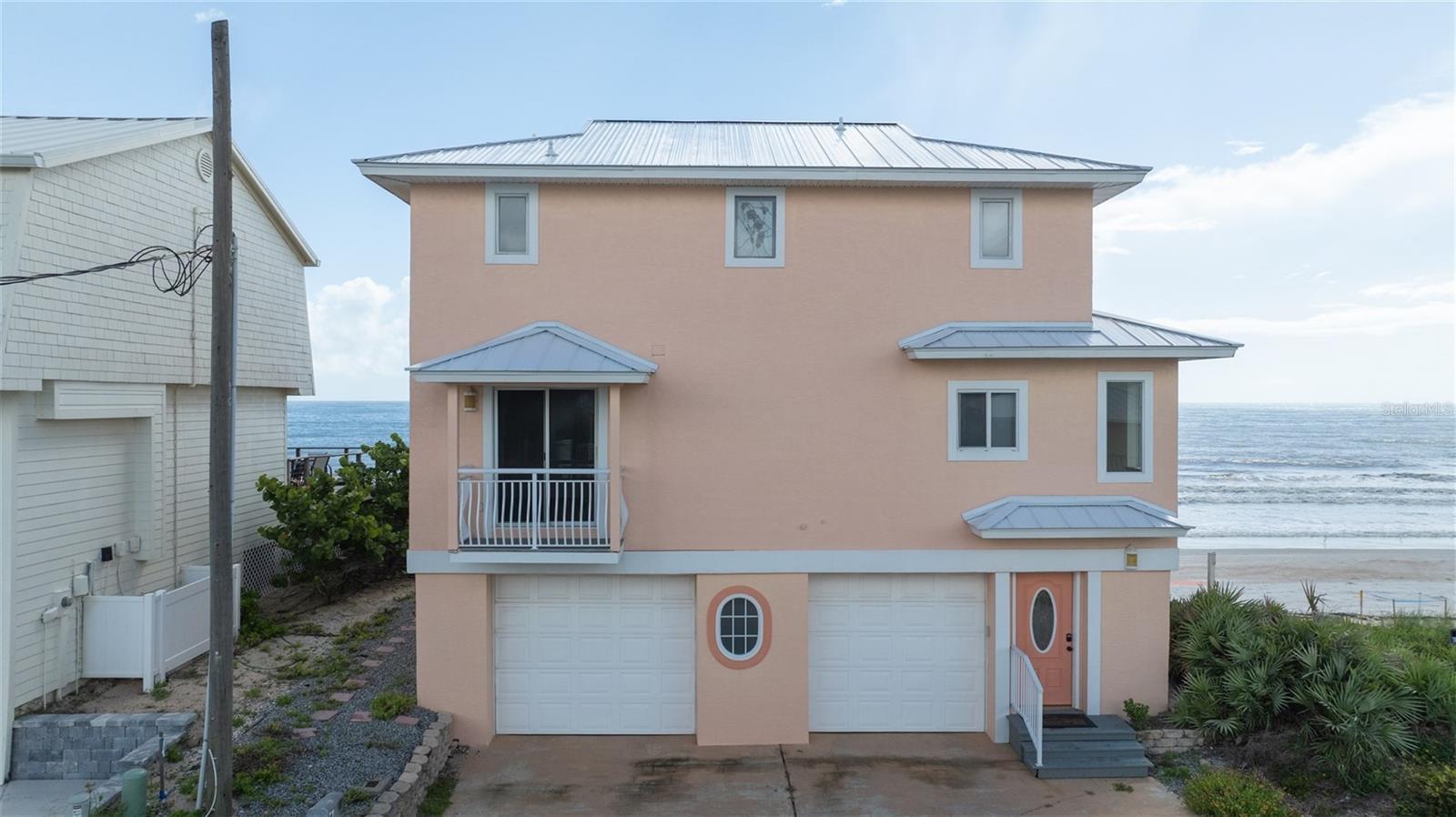 Live the beach life every day in this rare direct oceanfront home on the quiet south end of New Smyrna Beach. This 3-story home has over 2,000 square feet of space, 4 bedrooms, 2 full and 2 half baths, and an oversized 2-car garage. The main living area is on the second floor with a cozy fireplace has direct ocean views as well as an ocean-view kitchen and dining area, plus a guest bedroom and half bath. Step out to the large oceanfront deck and soak in the wide-open views. Situated on a protected lot with coquina rock revetment and no neighboring homes directly to the south, enjoy uninterrupted views and a sense of privacy that is truly unmatched. Private stairs take you right down to the no-drive beach where you can surf, fish, sunbathe, or take long walks while watching the sunrise or sunset. You might even catch dolphins playing or sea turtle hatchlings making their way to the ocean! Upstairs you'll find two oceanfront guest bedrooms, a guest bath, and the oceanfront primary suite with its own ensuite bath and another half bath. A new metal roof was added two years ago, and the windows are hurricane-impact with extra shutters for peace of mind. One of the two A/C units isn’t working, and the home is being sold AS-IS, but a small investment inside and out could easily turn this into your dream beach home—with equity to spare. Don’t miss this rare opportunity to own a true oceanfront paradise in NSB! ALL INFORMATION IS ASSUMED ACCURATE BUT NOT GUARANTEED. ALL MEASUREMENTS ARE APPROXIMATE. BUYERS AND THEIR AGENTS SHALL VERIFY ANY INFORMATION DEEMED IMPORTANT TO THEM.