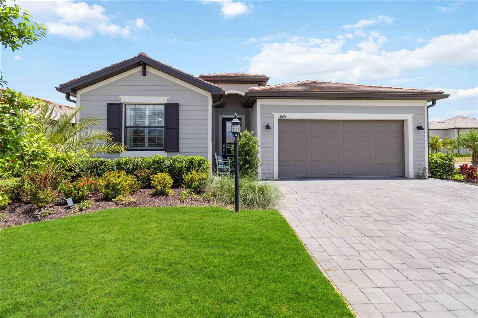 Nestled in the prestigious community of Lorraine Lakes in Lakewood Ranch, this stunning 4-bedroom, 3-bath home, built in 2023, offers over 2,000 square feet of luxurious living space. Recognized as one of the top master-planned communities in the nation, Lakewood Ranch boasts an amazing school district and a vibrant, welcoming environment.
The home features dual en-suites, perfect for multigenerational living, and a primary suite with an extra-large shower and dual vanities. Natural gas is a luxurious addition in Florida, and the cabinetry in all three bathrooms is topped with beautiful granite countertops. Additionally, unlike many new construction homes in the area, this home already has gutters conveniently installed.
The home's interior is freshly painted in bright, inviting colors and custom light fixtures and plantation shutters add a personal touch throughout. The widened driveway and spacious fenced backyard on an oversized corner lot offer plenty of outdoor space, with serene views of the lake. There has been an abundance of landscaping added to the backyard as well as to meticulously plan for future privacy.
The kitchen is a chef's dream, featuring modern appliances, a large island, and abundant storage. The living area flows seamlessly into the outdoor living space, perfect for entertaining or simply enjoying the peaceful lake views.
Lorraine Lakes offers a lifestyle unmatched in the area with amenities such as a massive clubhouse, fitness center, resort-style pool, splash pad, lap pool, indoor basketball court, arcade, tennis and pickleball courts, bocce, volleyball, a well-maintained restaurant, and more.
Whether you're looking for a peaceful place to call home or a vibrant neighborhood with activities at every turn, this home truly offers it all in one of the nation’s top master-planned communities.