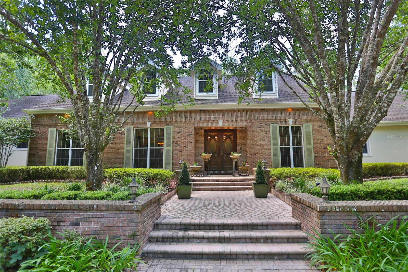 This incredible residence features beautiful gardens on 5 +/- acres in the equine-friendly gated community of Polo Lane. Private tree-lined drive leads to a very elegant and comfortable traditional-style residence. The 4 bedroom, 4.5 bath residence with 5,800 + SF offers a warm welcoming entry foyer leading to a lovely office, formal dining room, spacious family room featuring a fireplace, built-in entertainment center, and glass sliding doors leading to the charming outdoors. The family room is open to the beverage bar, Chef's kitchen, and breakfast nook with large windows to enjoy the delightful views of the pool and gardens. Split floor plan for added privacy. Spacious Owner’s suite with glamourous bath featuring a steam shower. Exercise room and an attractive stairway that leads to the second-floor entertaining area and media room. Added bonuses are a KOI pond, putting green, a cabana with a fireplace and generous seating, and a generator for your peace of mind. This truly a property offers something for everyone in the family. Great location close to Publix, shopping, and medical facilities.